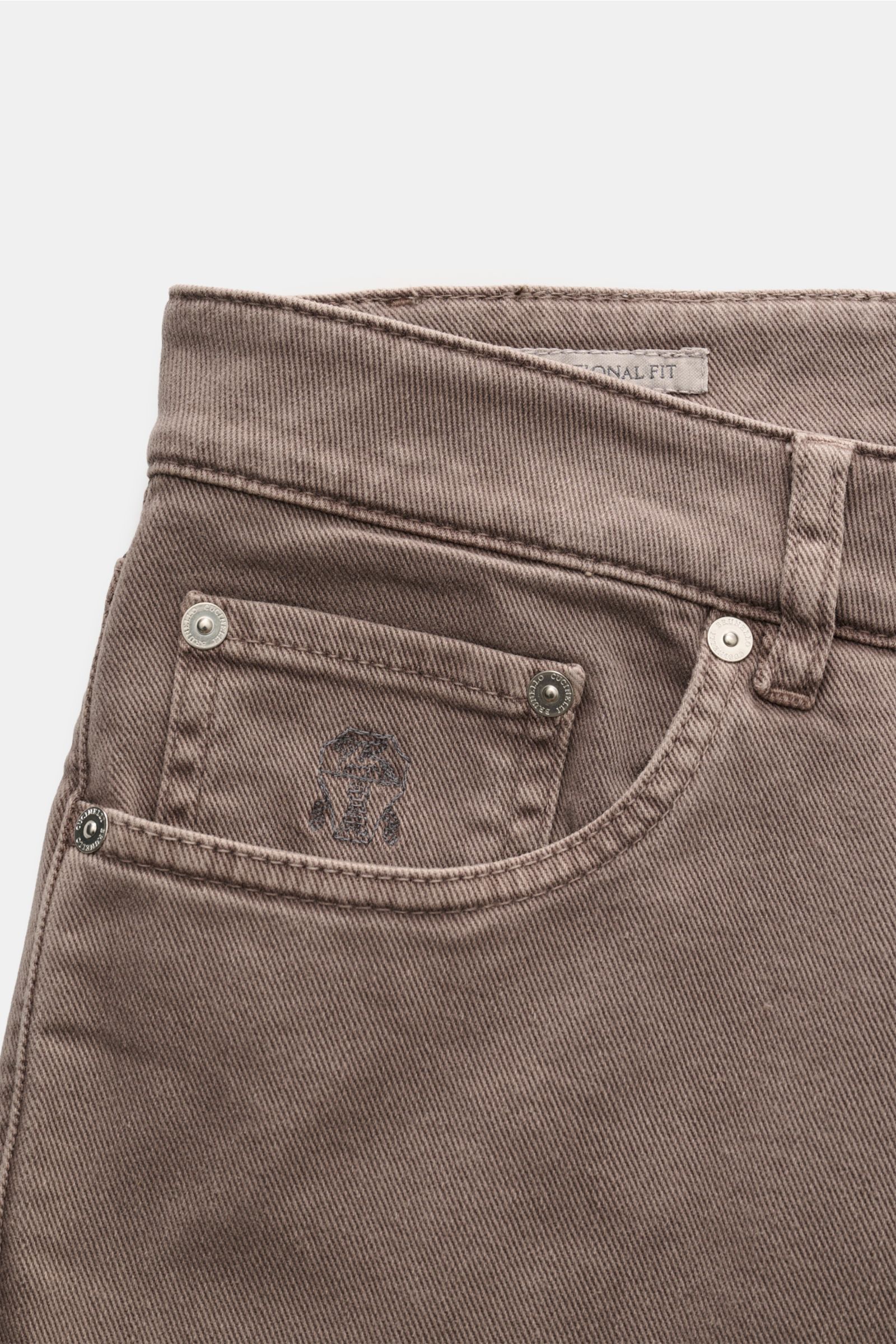 Close-up front view of Brunello Cucinelli Jeans 'Traditional Fit' taupe showcasing lightweight elastic cotton denim, five-pocket style with logo-stitched coin pocket, button fly, and a textured leather patch. Luxuriöser Denim-Klassiker von BRUNELLO CUCINE