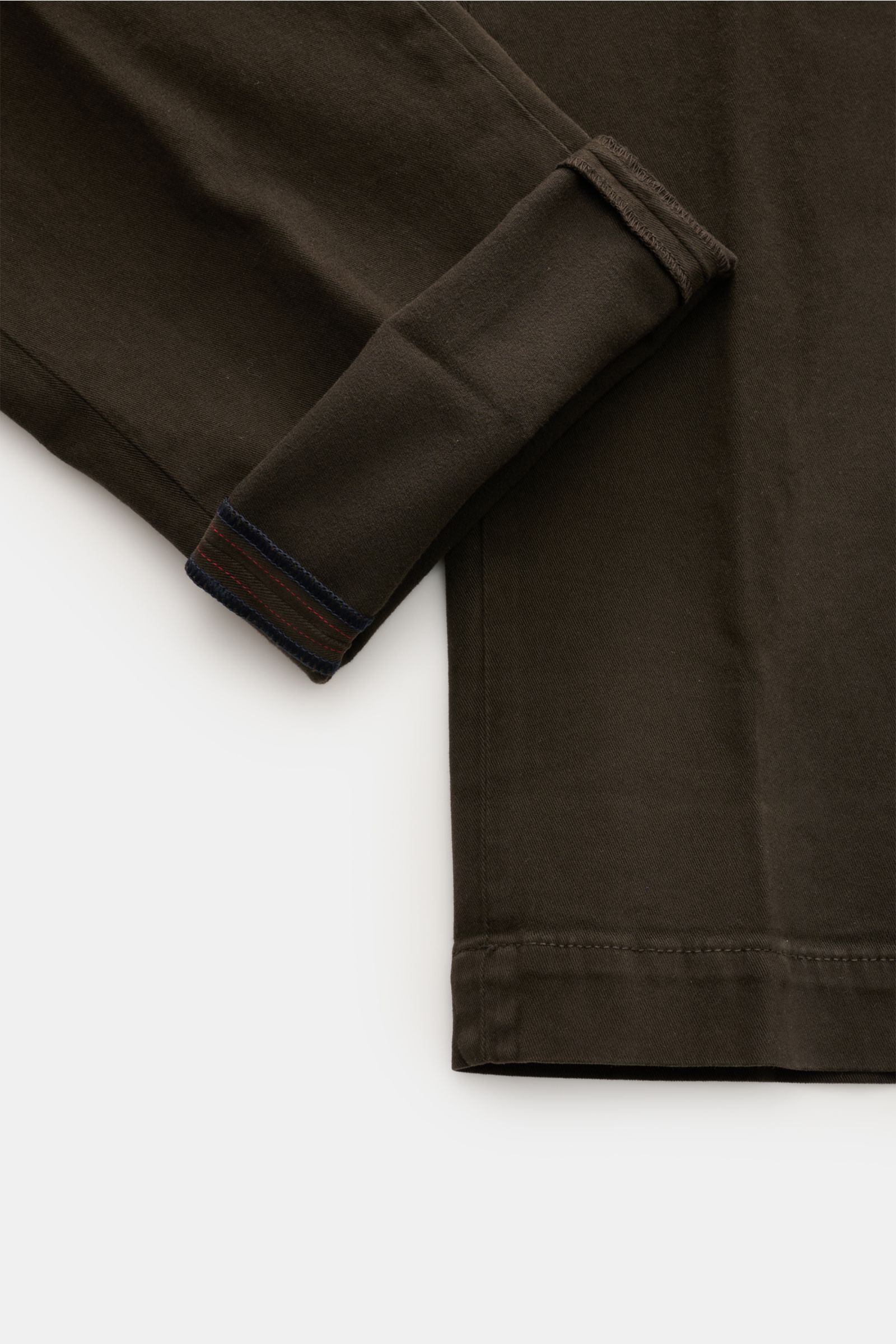 Mason's Chino 'Torino Style' dunkelbraun, Twill aus Baumwolle, slim Fit, niedrige Bundhöhe, schmal zulaufend, garment dyed, weicher Griff, Zip Fly, Bundknopf, französische Taschen, paspelierte Gesäßtaschen mit Knopf, Detailansicht Saum und Beininnenseite.