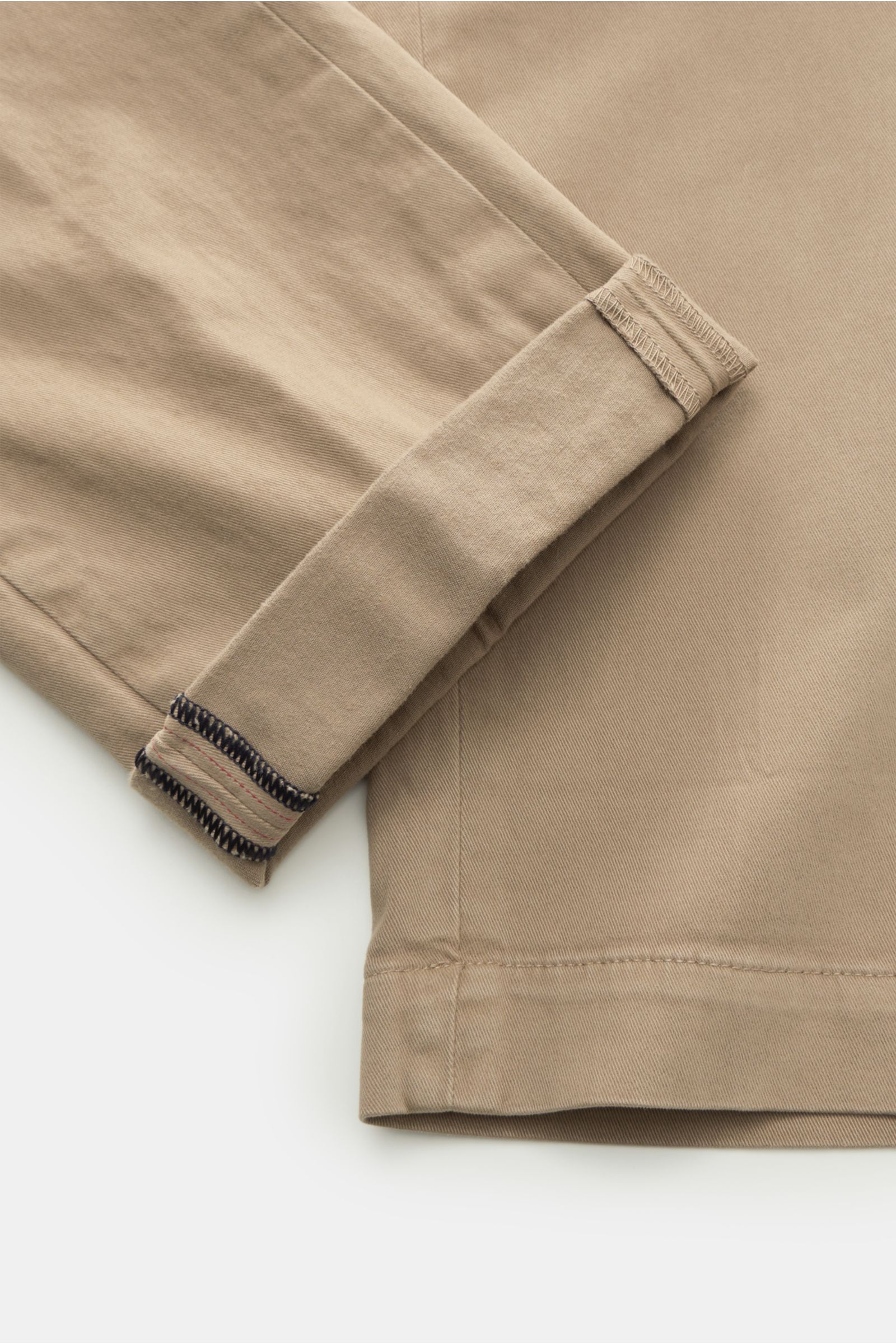 Close-up image of Mason's Chino 'Torino Style' taupe showing the folded cuff and lower leg area from a top-down perspective. Twill aus Baumwolle, leicht elastische Qualität, weicher Griff, garment dyed, Slim Fit, niedrige Bundhöhe, schmal zulaufend, Zip F