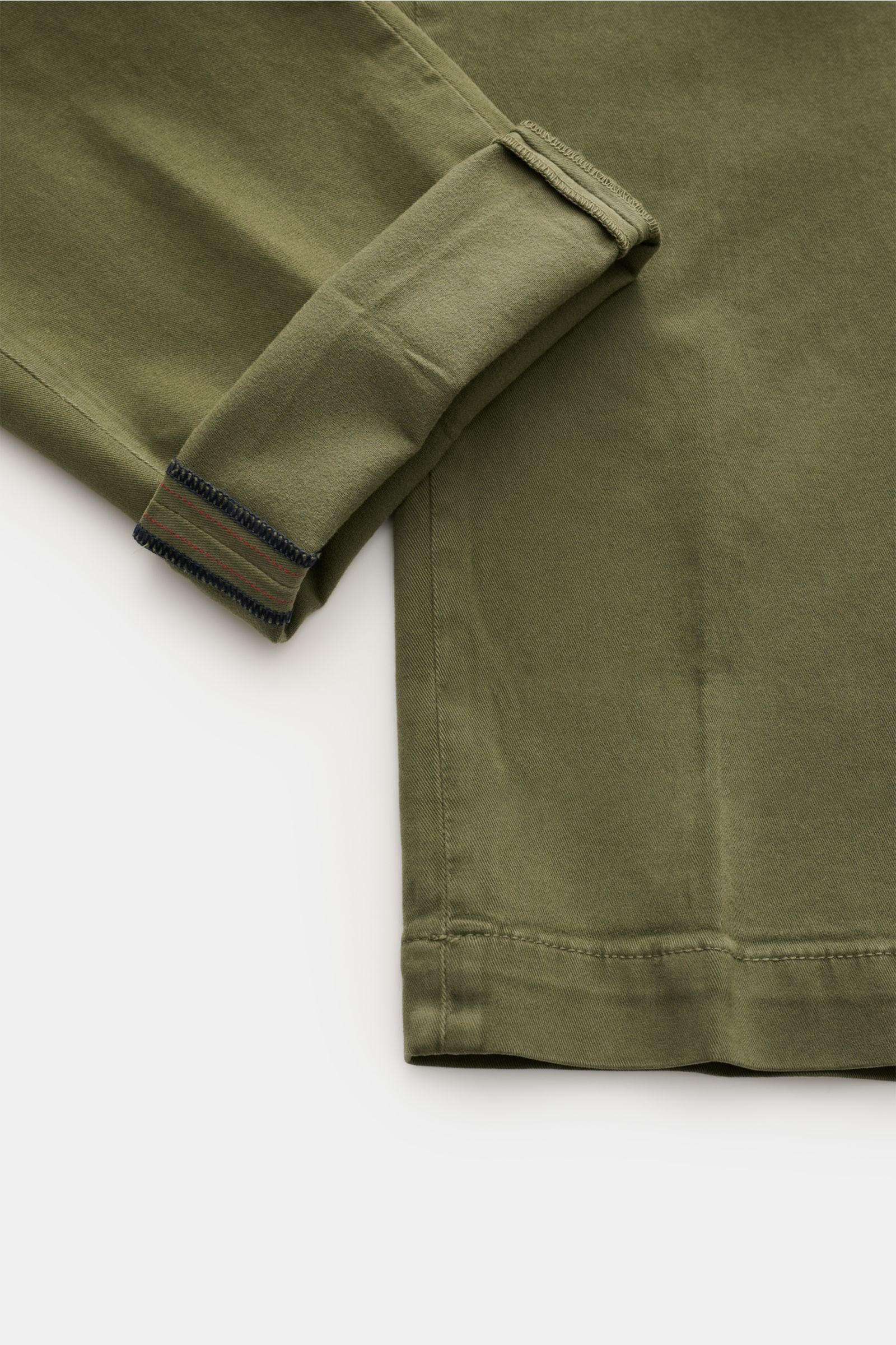 Das Bild zeigt eine Nahaufnahme vom Saum und Ärmel eines graugrünen Mason's Chino 'Torino Style' aus Twill-Baumwolle, leicht elastisch, weicher Griff, garment dyed, Slim Fit, niedrige Bundhöhe, schmal zulaufend, mit Zip Fly, Bundknopf, französischen Tasch