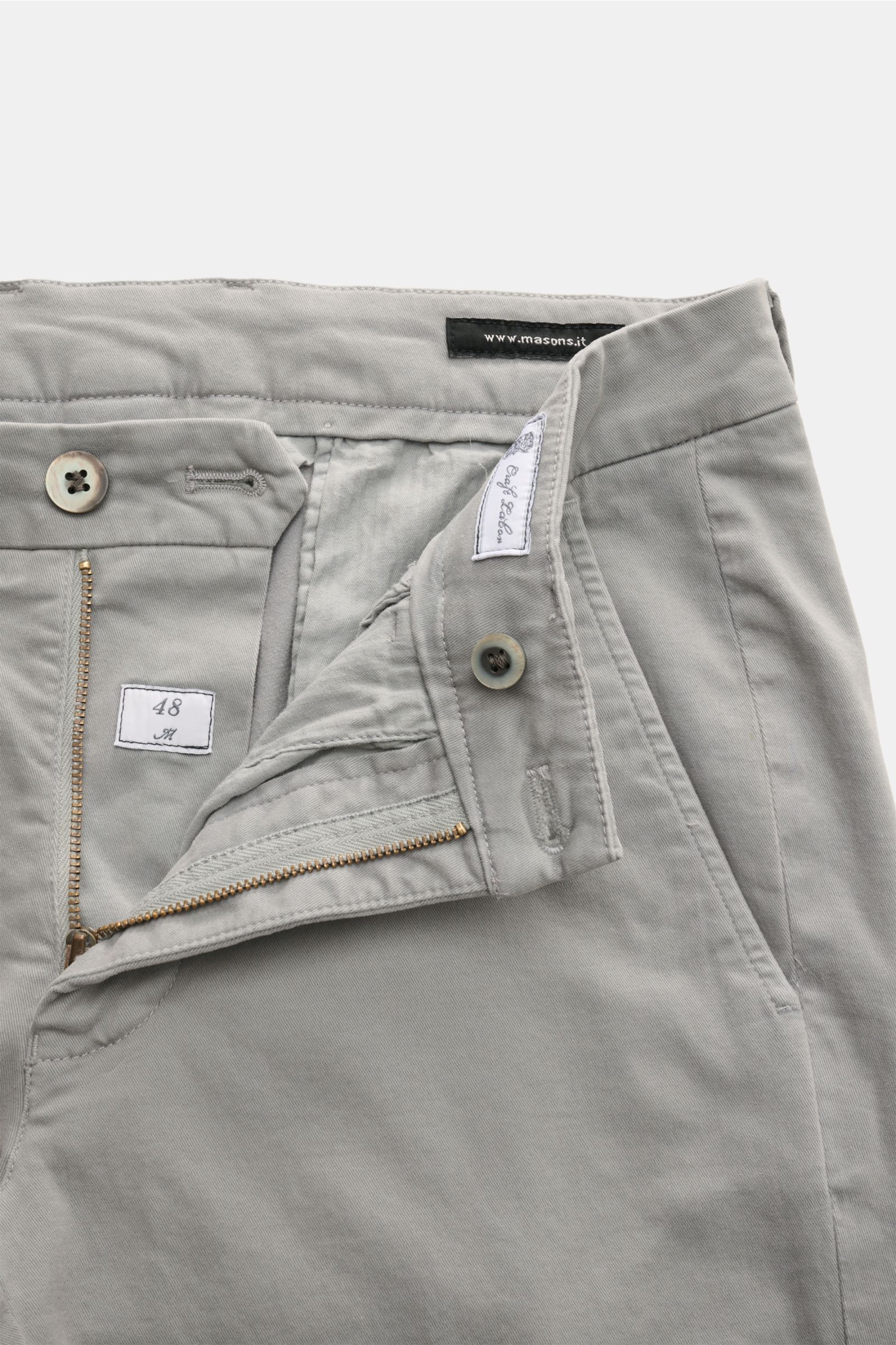 Mason's Chino 'Torino Style' grau, von oben fotografiert mit offenem Zip Fly, Bundknopf, französischen Taschen, schmal zulaufend, Slim Fit, Twill aus Baumwolle, leicht elastisch, weicher Griff, garment dyed, niedrige Bundhöhe, paspelierte Gesäßtaschen mit