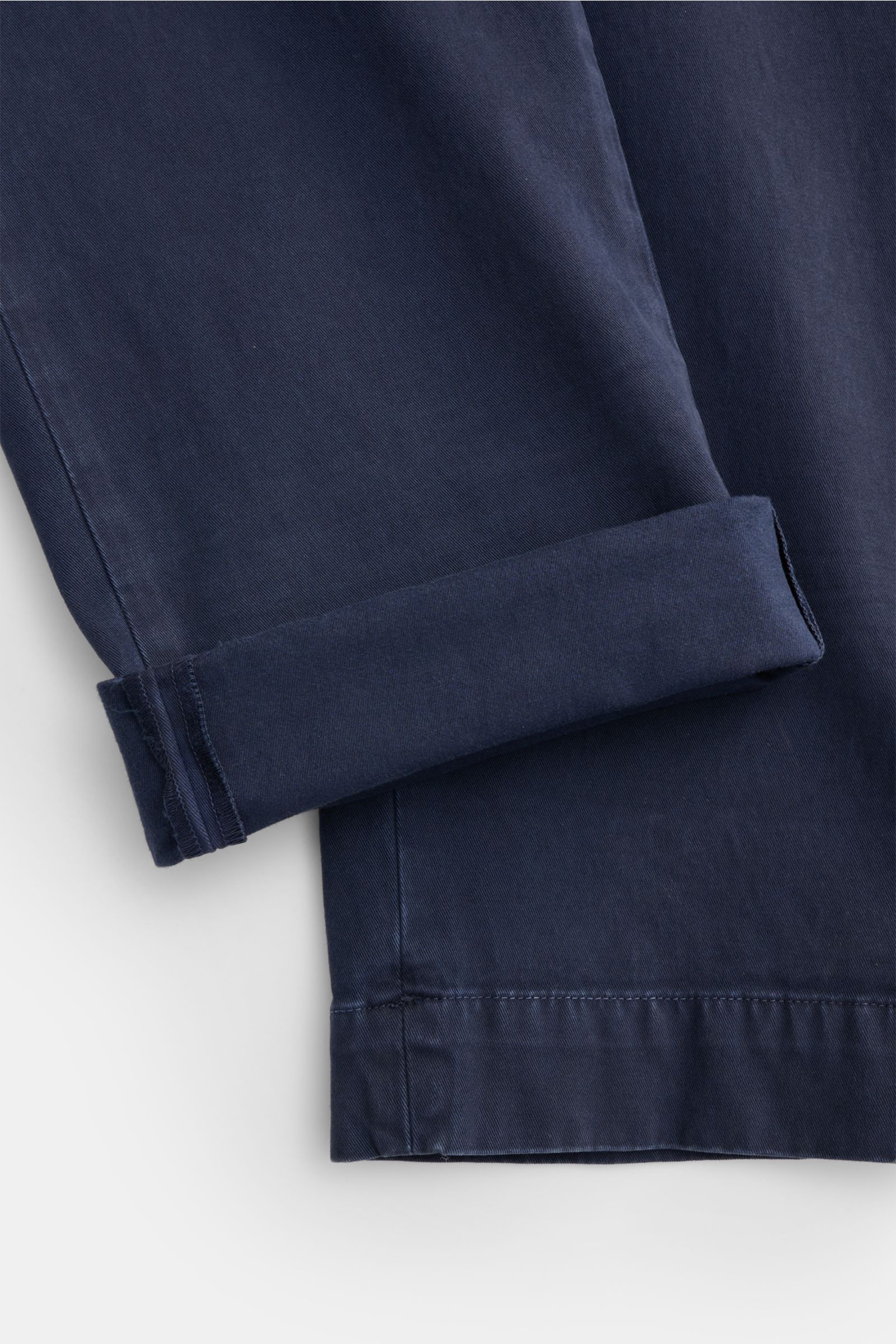 Close-up image of the hem and cuff of Mason's Chino 'Boston Style' navy, photographed from a top-down perspective, showcasing twill cotton, lightly elastic, soft touch, garment dyed, Regular Fit, slightly tapered leg, zip fly with button, French pockets, 