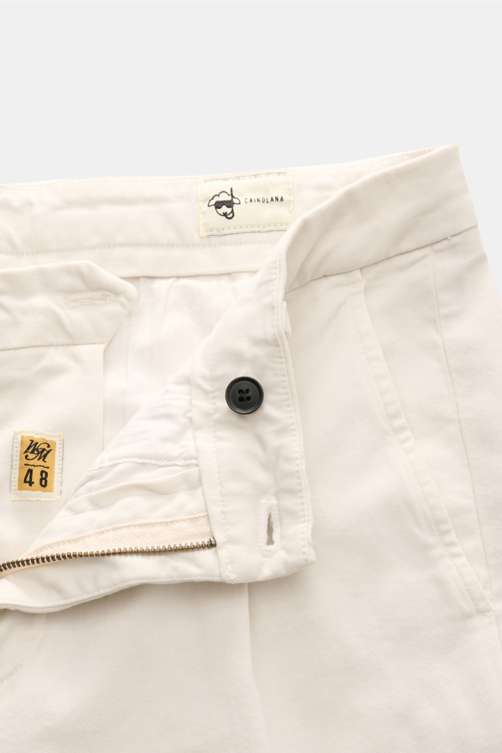 Nahaufnahme der geöffneten Mason's Chino 'Osaka Style' sand aus Twill Baumwolle und Wolle, Regular Fit, mit Zip Fly, Bundknopf, französischen Taschen, einfacher Bundfalte und paspelierten Gesäßtaschen mit Knopf.