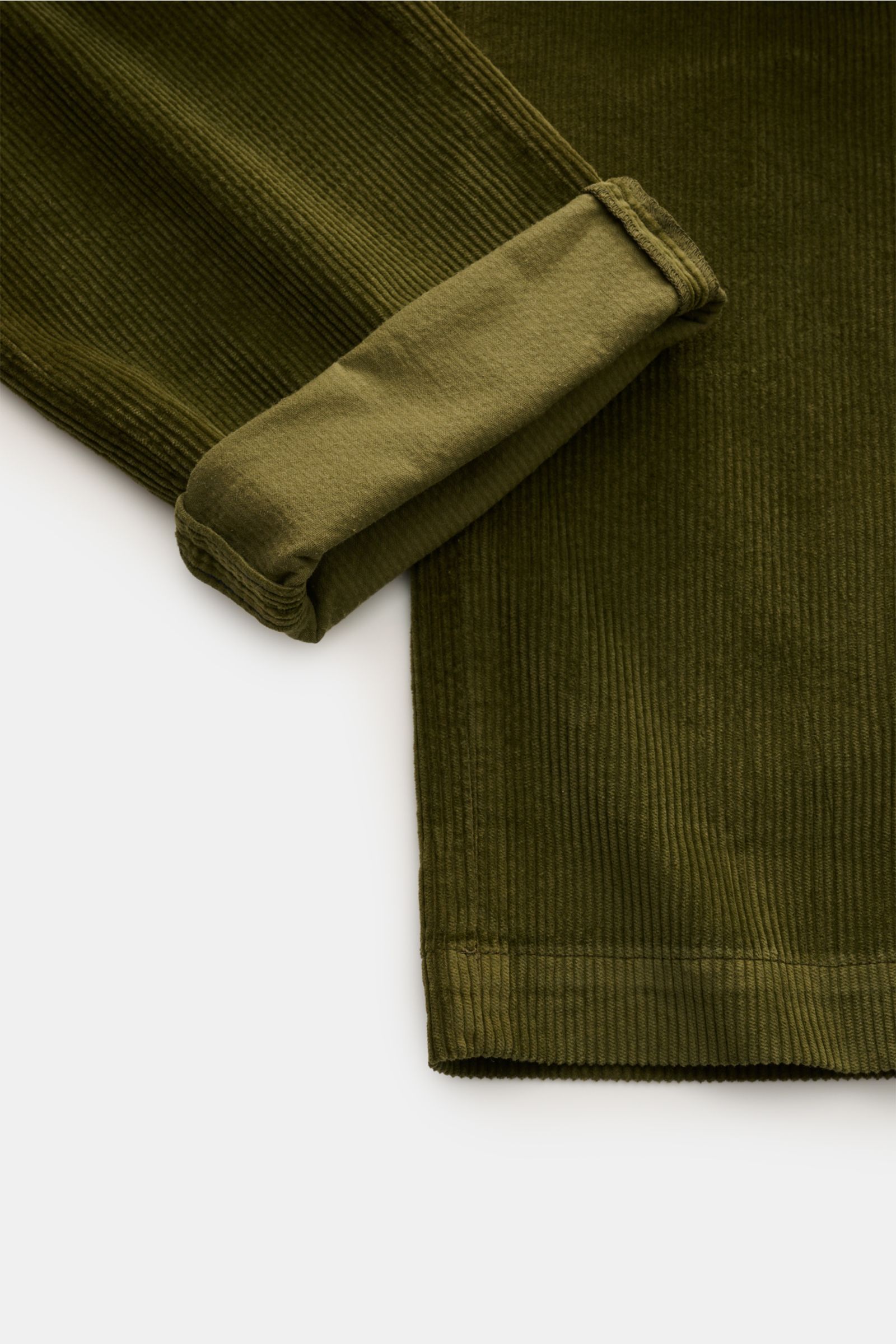 Nahaufnahme der umgeschlagenen Beinöffnung der Mason's Cordhose 'New York Style' oliv aus weichem Baumwoll-Lyocell-Cord mit feiner Rippenstruktur, fotografiert von oben.