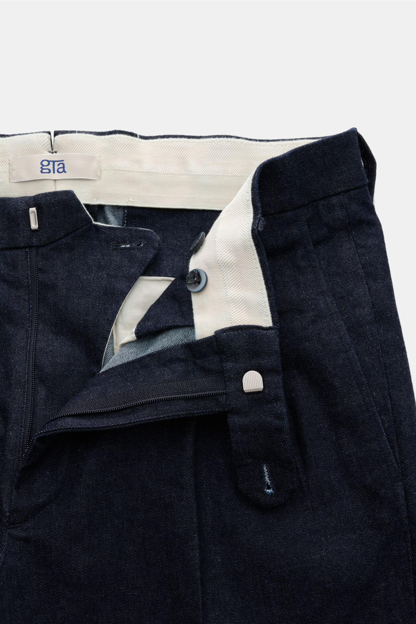 GTA Jeans 'Luca' navy aus Baumwoll-Denim mit leichtem Stretch, Tapered Fit, Bund mit Waist Comfort Band, Reißverschluss, Bundknöpfen, doppelte Bundfalte, französischen Taschen, dezentes Logo, paspelierte Gesäßtaschen mit Knopf und fixiertem Saumaufschlag,