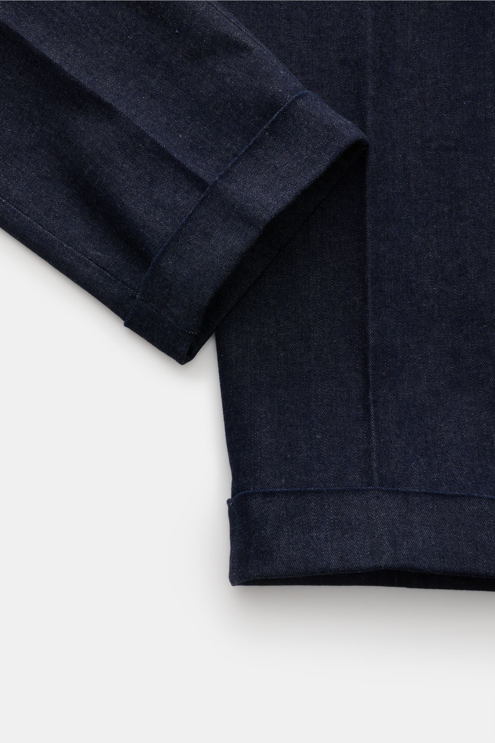 Nahaufnahme des fixierten Saumaufschlags und eines Ärmels der GTA Jeans 'Luca' navy aus Baumwoll-Denim mit leichtem Stretch, Tapered Fit und französischen Taschen.