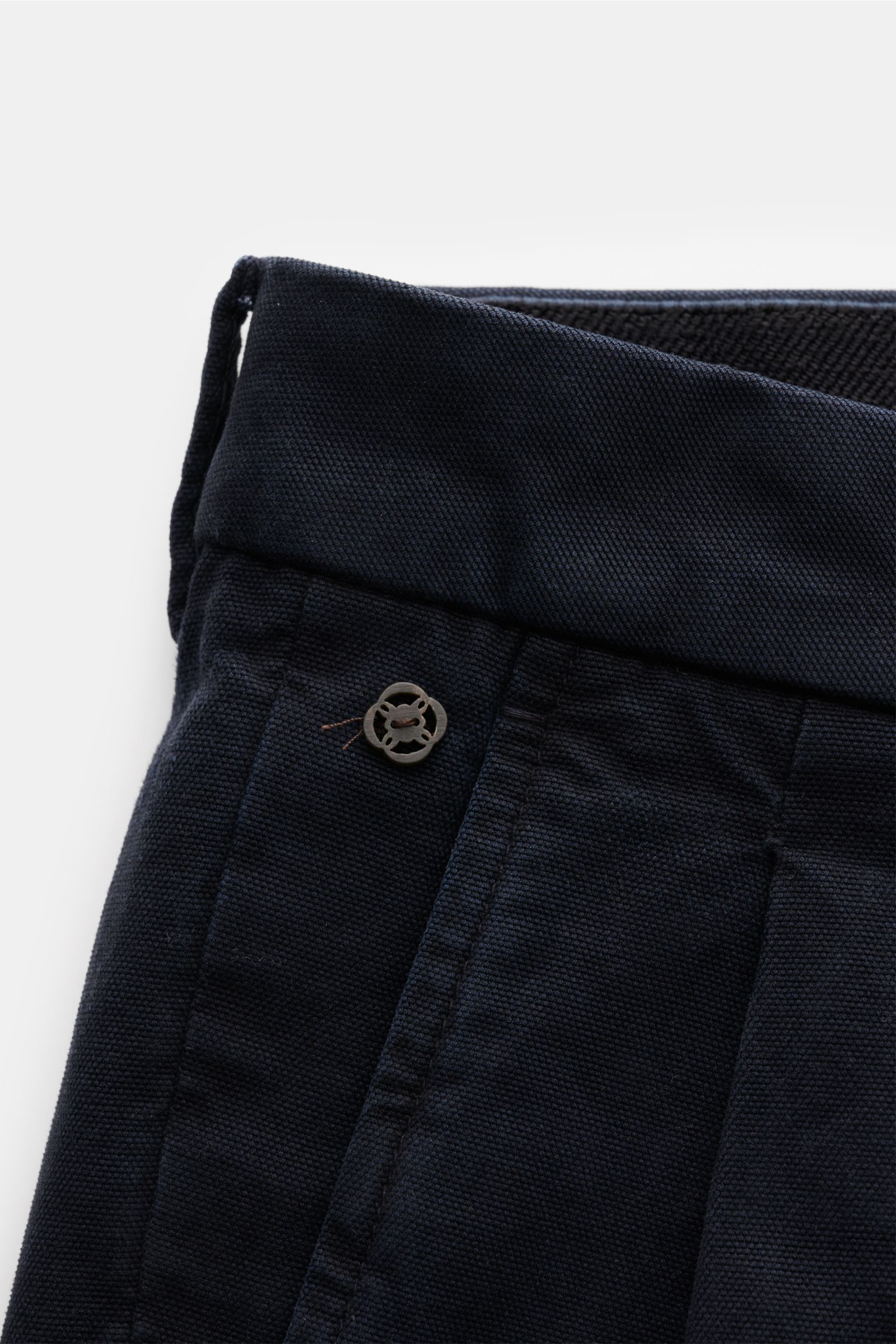 Close-up front view of the navy GTA Hose 'Luca' showing high-quality cotton-modal fabric with tapered fit, double pleat, elastic waistband, and logo detail.