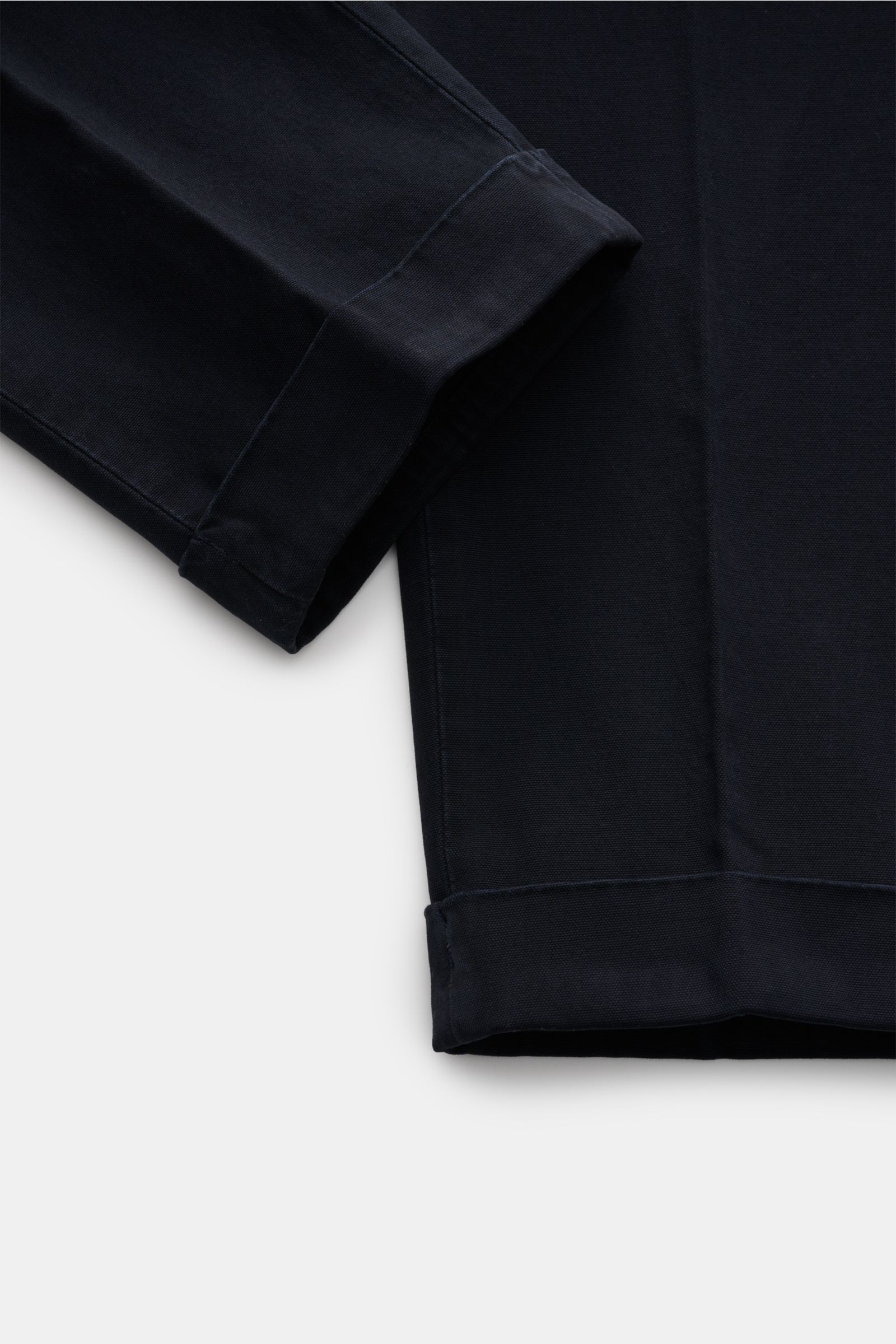 Close-up front view of the cuff and lower leg of the GTA Hose 'Luca' navy, made from a soft, lightweight cotton-modal mix with slight elasticity, tapered fit, double waistband pleat, fixed hem cuff, and fine stitching details. Die Hose 'Luca' von GTA über