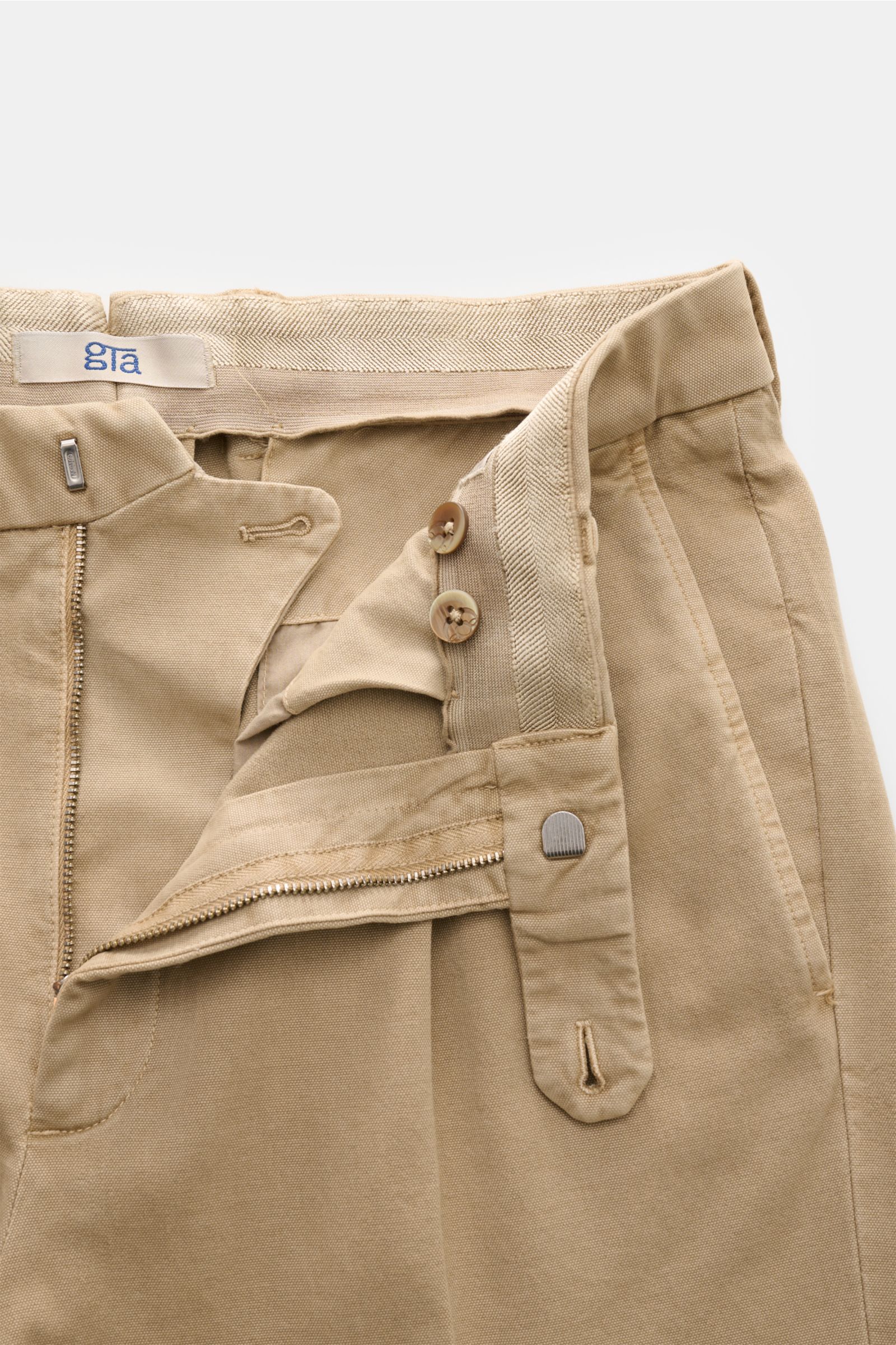 GTA Hose 'Luca' beige, schmal zulaufend im Tapered Fit, Baumwoll-Modal-Mix mit Reißverschluss, Bundhaken, elastischem Bund und fixiertem Saumaufschlag, Detailansicht von oben.