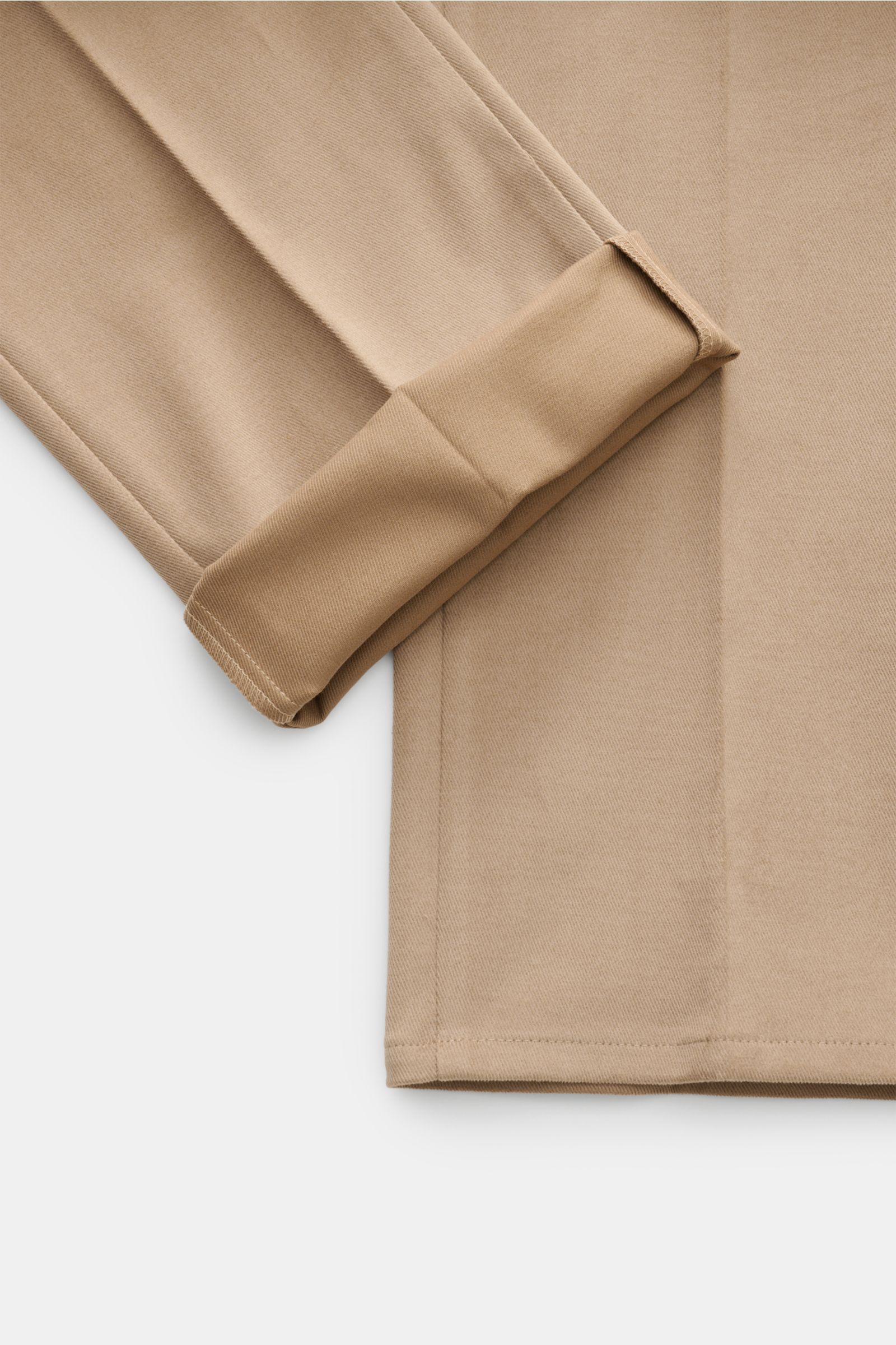 Close-up image of the folded cuff and lower leg of the GTA Chino 'Federico' hellbraun, photographed from a top-down perspective. Twill aus Baumwolle, leicht elastische Qualität, sehr weicher Griff, Regular Fit, leicht schmal zulaufend, Reißverschluss und 