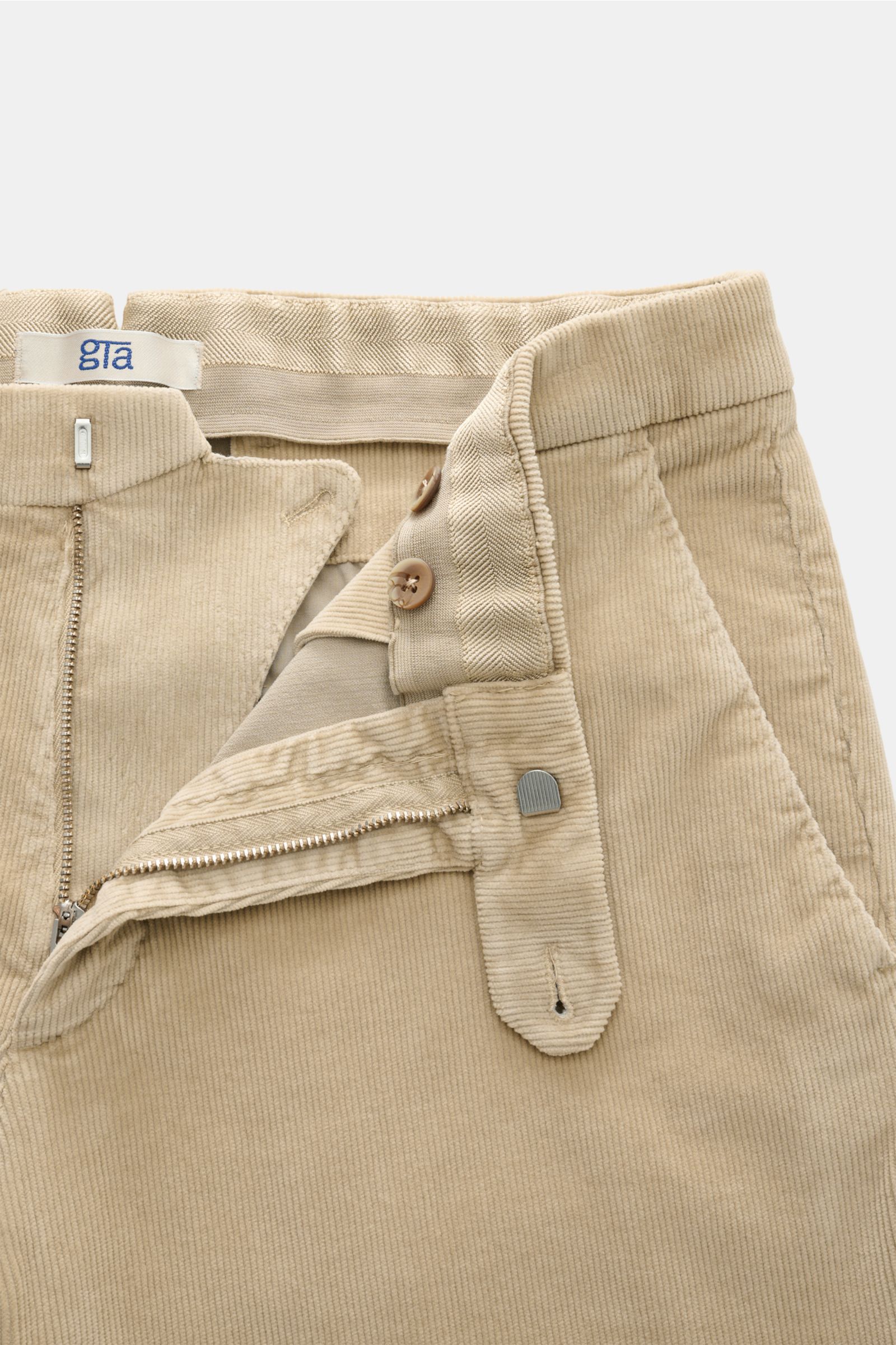 GTA Cordhose 'Federico' beige, Frontdetail, Feincord aus Baumwolle und Modal, Slim Fit, leicht elastisch, weicher Griff, Reißverschluss, Bundknopf, elastischer Bund, französische Taschen, paspelierte Gesäßtaschen mit Knopf.