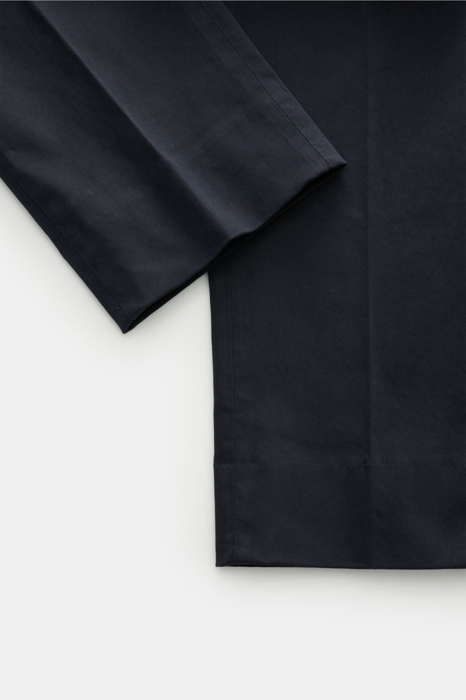 Close-up image of the cuff and lower leg area of GTA Cotton trousers 'Dennis' navy, photographed from above to show the fixed hem turn-up and tapered fit. The cotton trousers 'Dennis' by GTA are defined by their soft feel and feature an elasticated wai