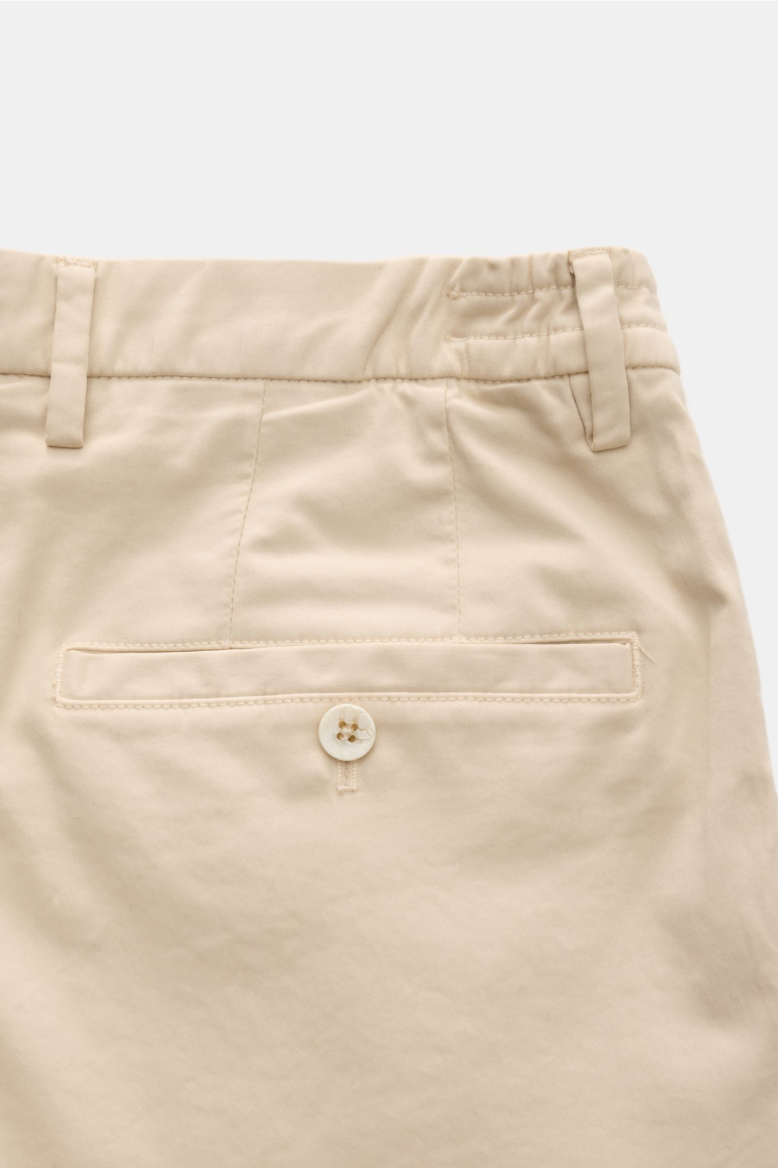 GTA Cotton trousers 'Dennis' sand shown from a close-up rear view, featuring a partially elasticated waistband, back pocket with button, belt loops, and soft, slightly elasticated cotton fabric with a tapered fit for comfort. 

The cotton trousers 'Den