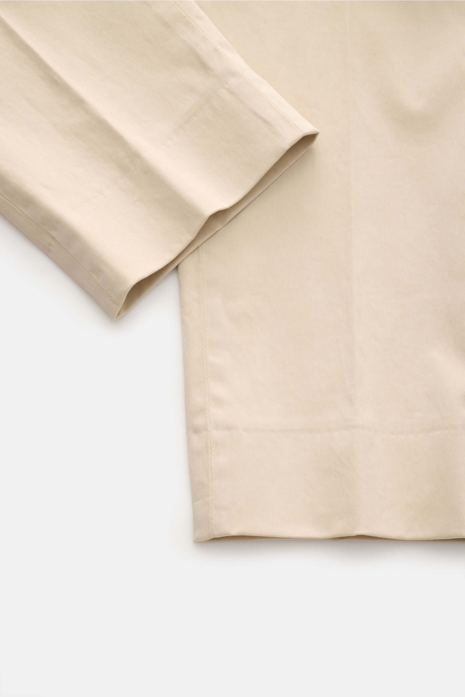 Close-up view of the lower part of GTA Cotton trousers 'Dennis' sand, showing the tapered ankle length with fixed hem turn-up and soft, slightly elasticated cotton fabric.

The cotton trousers 'Dennis' by GTA are defined by their soft feel and feature 