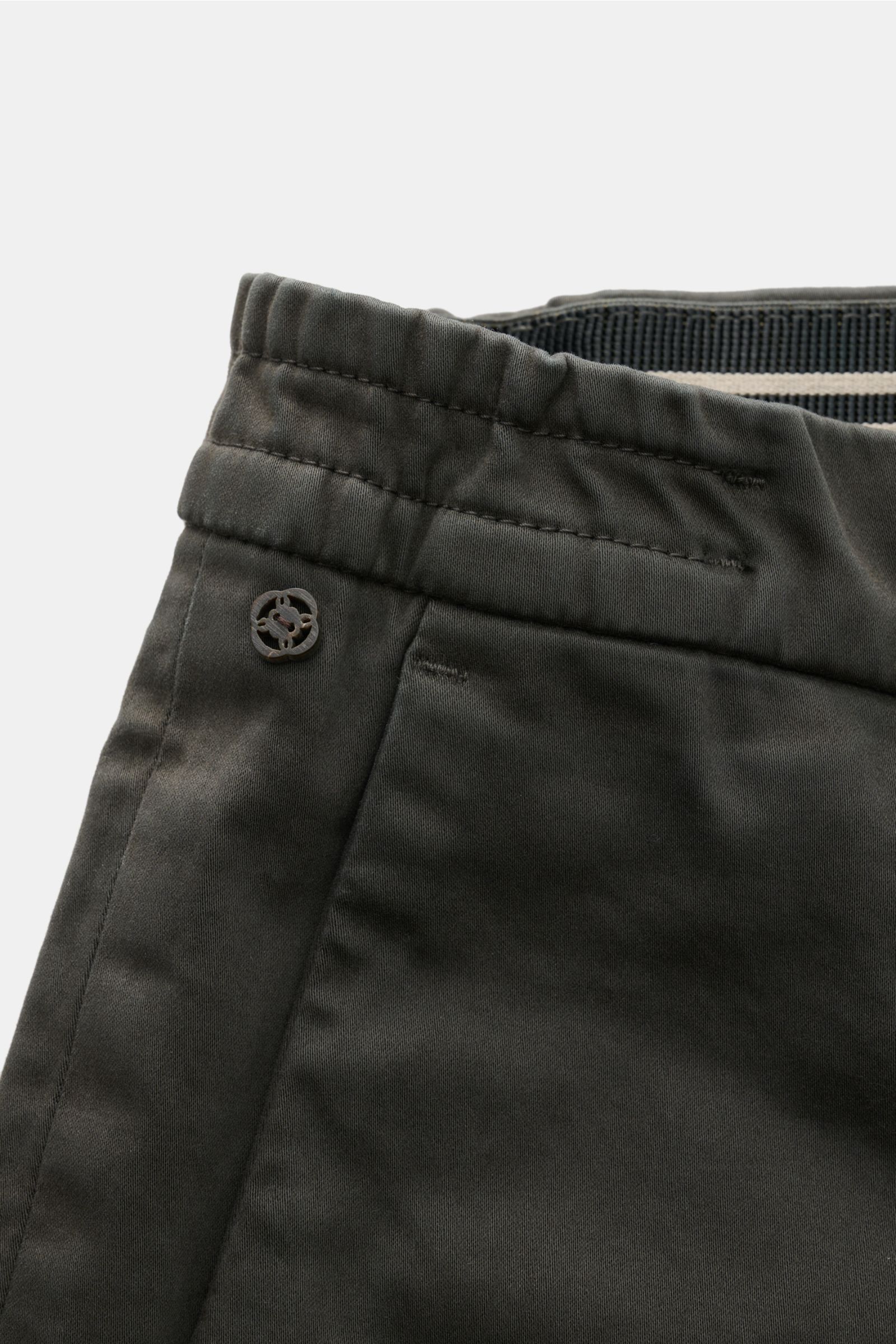 Close-up front side view of GTA Cotton trousers 'Dennis' dark grey featuring soft, slightly elasticated cotton, elasticated waistband, small logo detail, and French pocket. 

The cotton trousers 'Dennis' by GTA are defined by their soft feel and featur