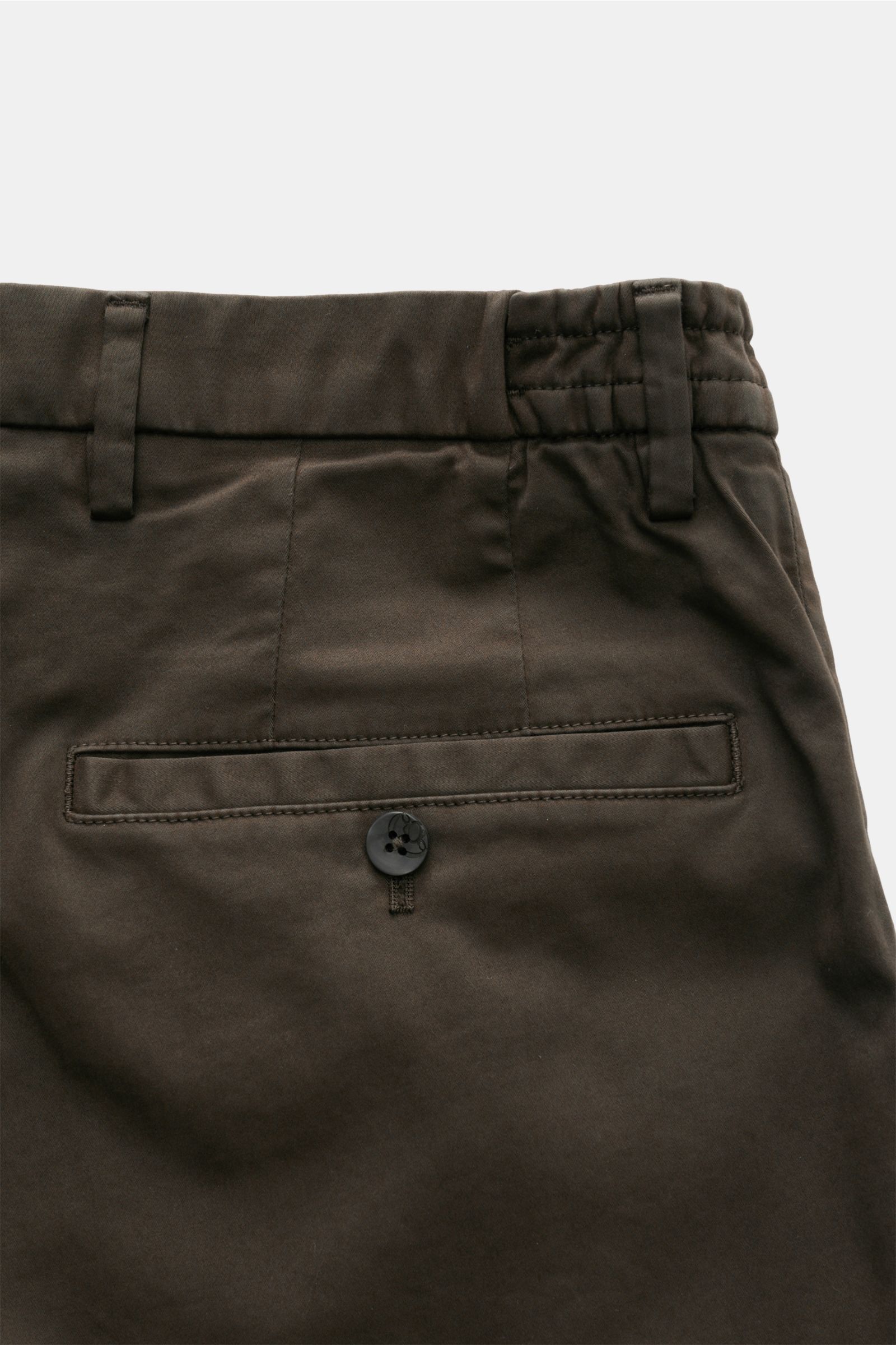 GTA Cotton trousers 'Dennis' dark brown shown from the back close-up, featuring a partially elasticated waistband, back pocket with button, and belt loops. 

The cotton trousers 'Dennis' by GTA are defined by their soft feel and feature an elasticated 
