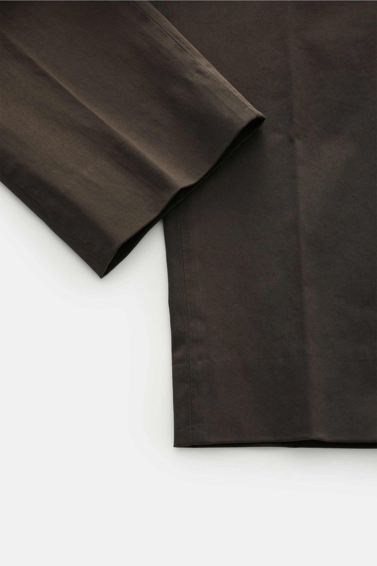 GTA Cotton trousers 'Dennis' dark brown shown from a close-up side angle, highlighting the soft, slightly elastic tapered fabric and fixed hem turn-up. 

The cotton trousers 'Dennis' by GTA are defined by their soft feel and feature an elasticated wais
