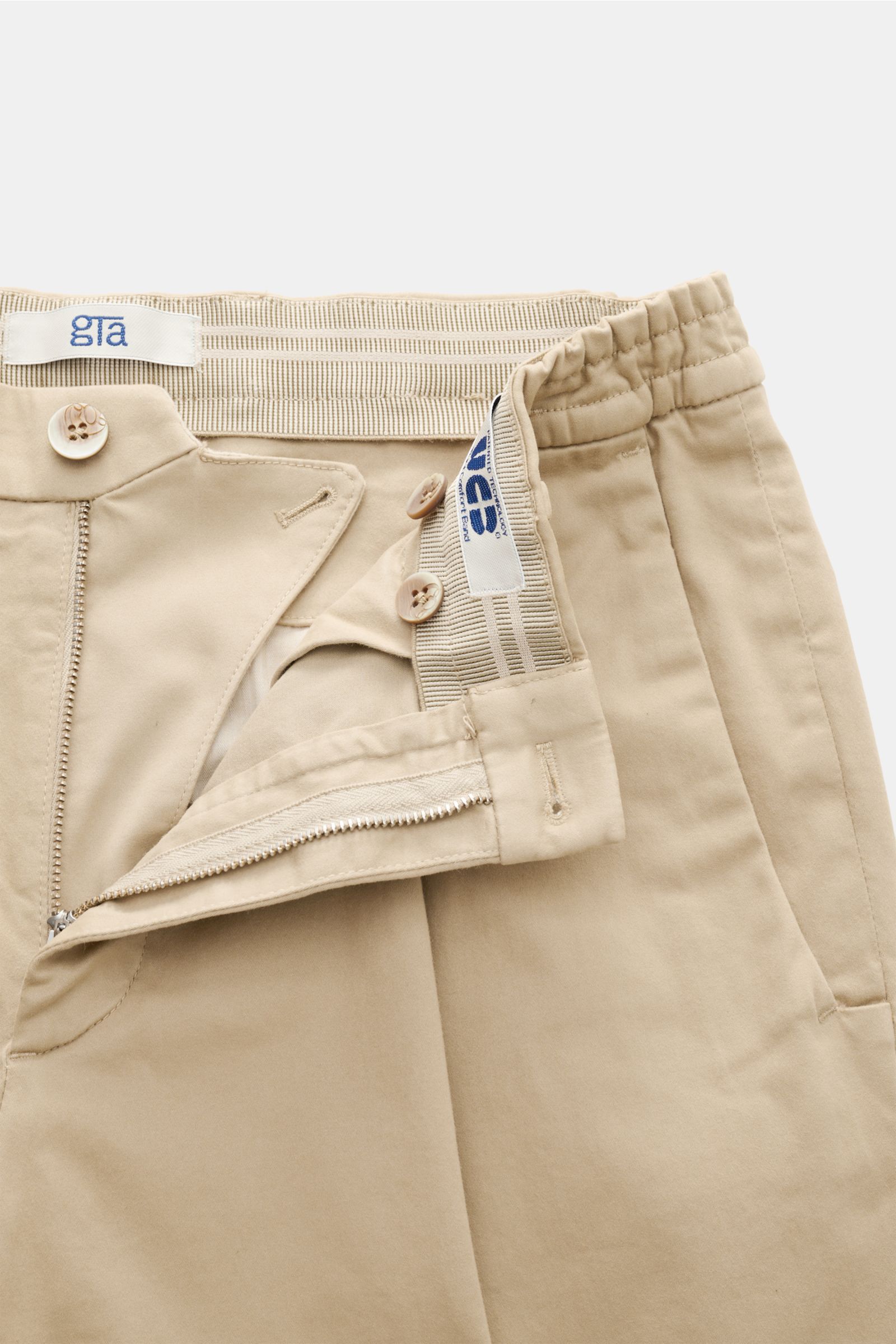 GTA Baumwollhose 'Dennis' beige von oben fotografiert, mit offenem Reißverschluss, teilelastischem Bund und weicher, leicht elastischer Baumwolle.