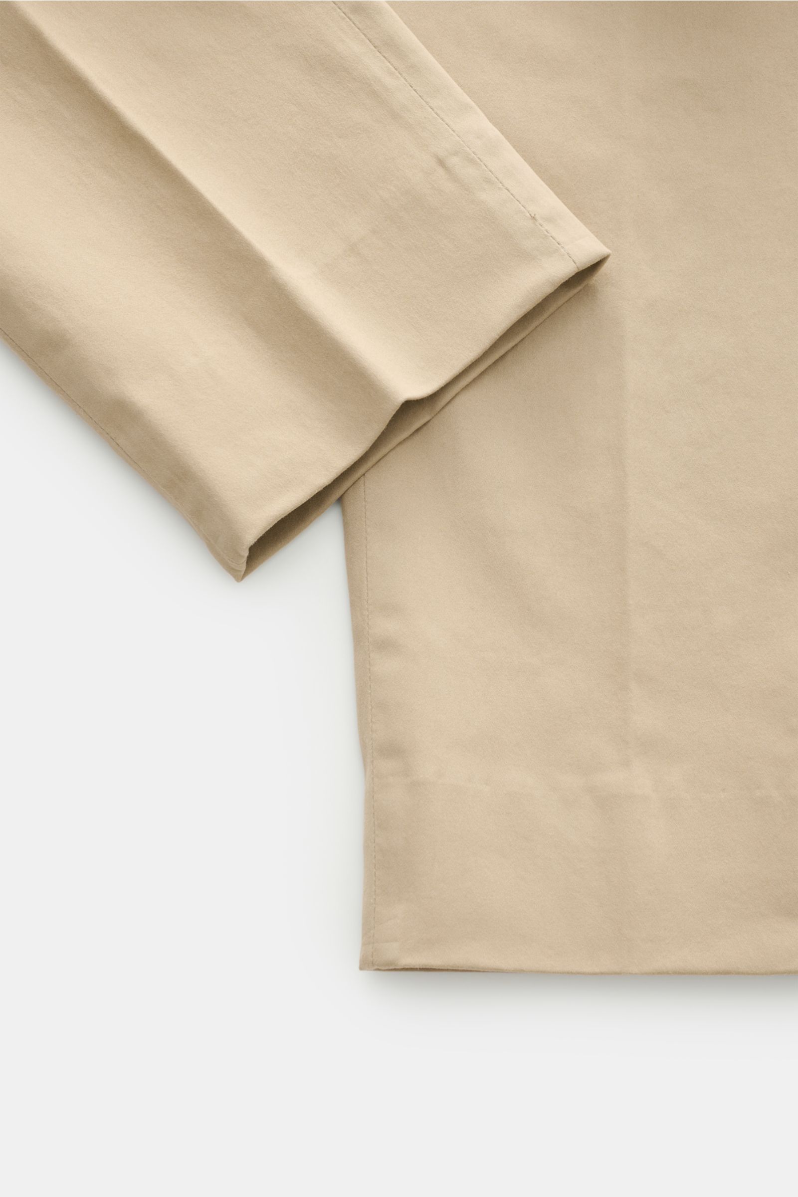 Nahaufnahme der beigefarbenen GTA Baumwollhose 'Dennis' im Tapered Fit, knöchellang mit fixiertem Saumenaufschlag.