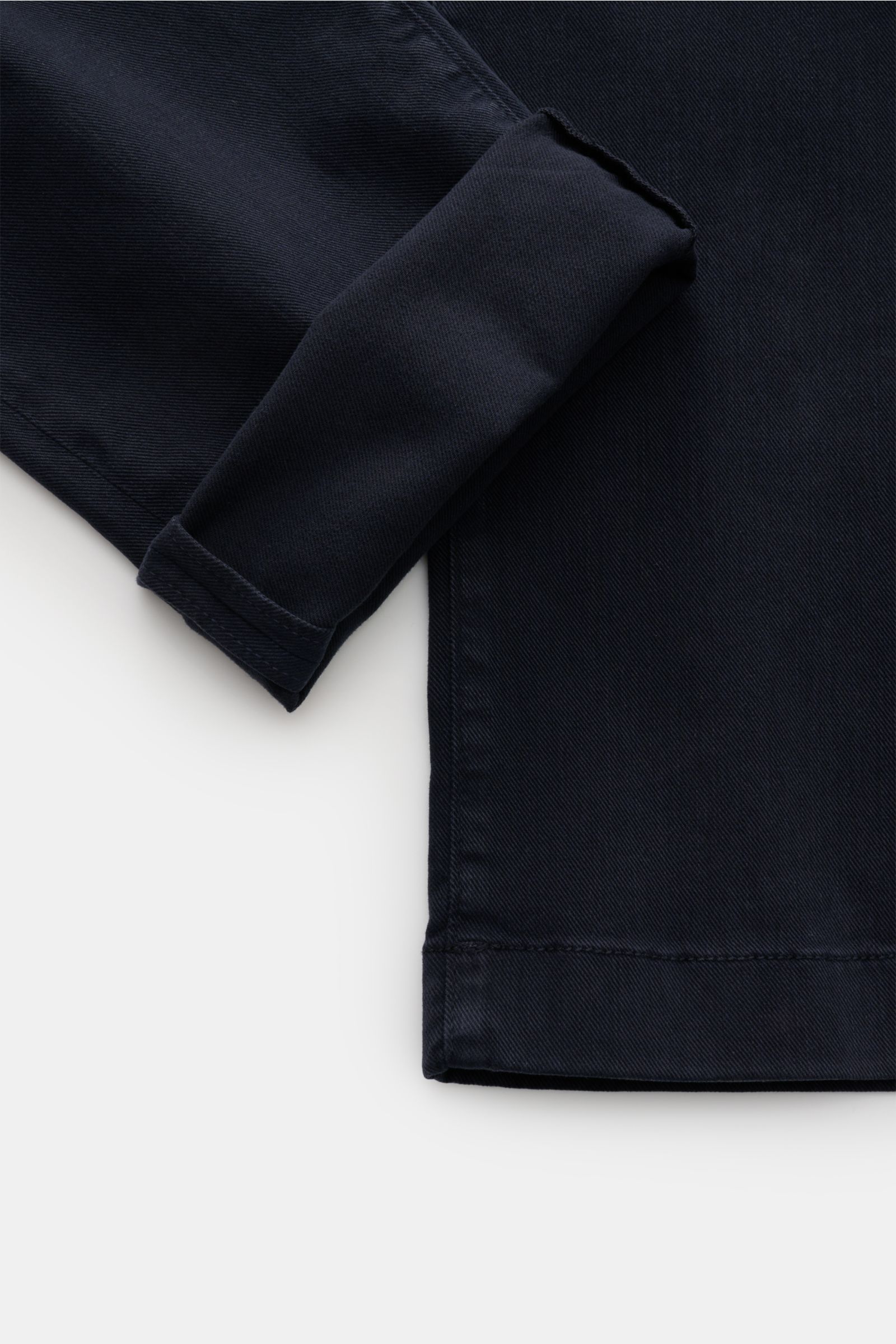 Close-up top-down view of Jacob Cohen Chino 'Bobby' navy showing precise stitching on the cuff and hem of slim-fit cotton and lyocell twill fabric. Präzise, italienische Handwerkskunst - dafür steht das Label JACOB COHEN und kreiert mit der Chino 'Bobby' 