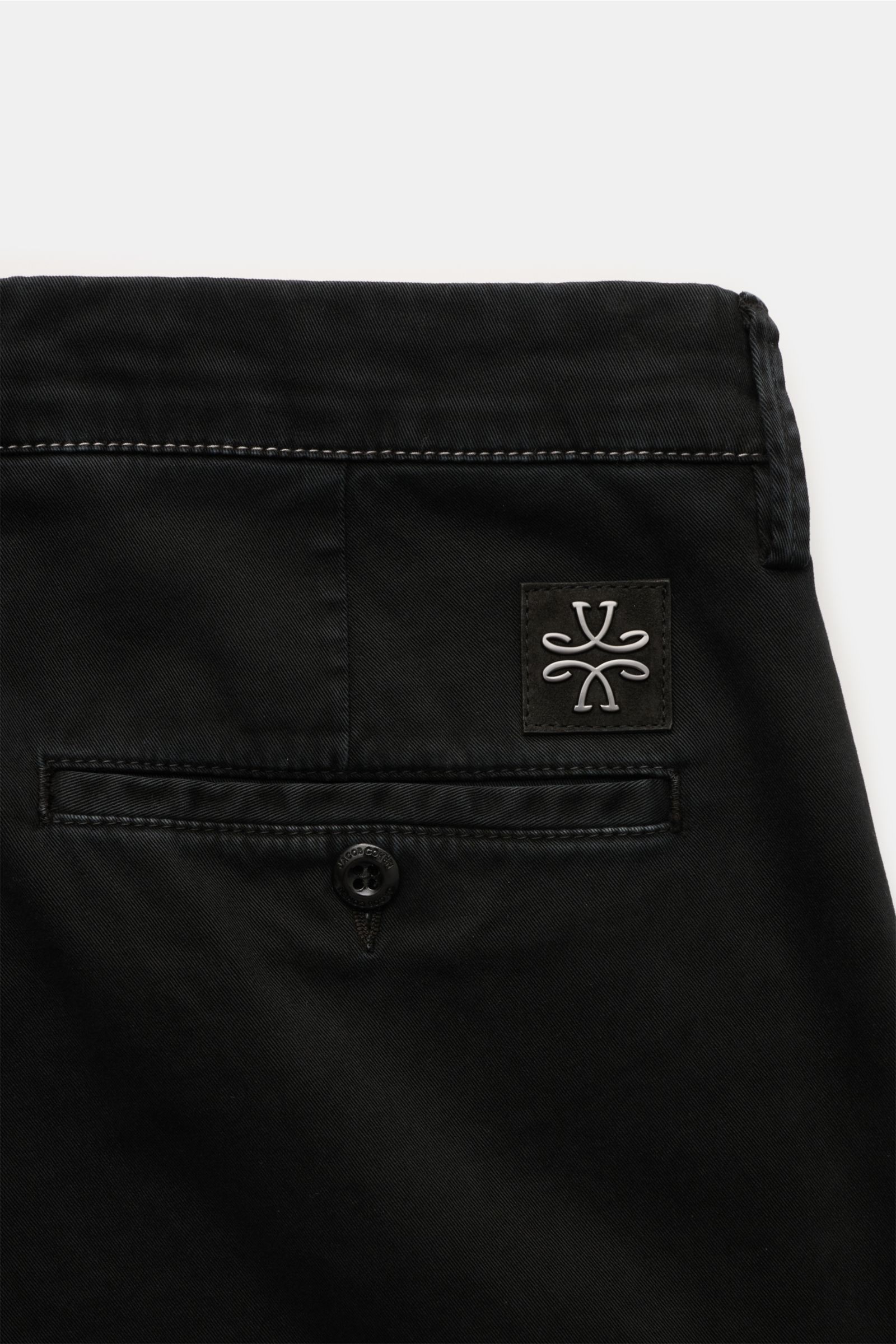 Close-up rear view of Jacob Cohen Chino 'Bobby' schwarz in black cotton twill, slim fit with buttoned back pocket and suede logo patch. Präzise, italienische Handwerkskunst - dafür steht das Label JACOB COHEN und kreiert mit der soften Chino 'Bobby' aus k