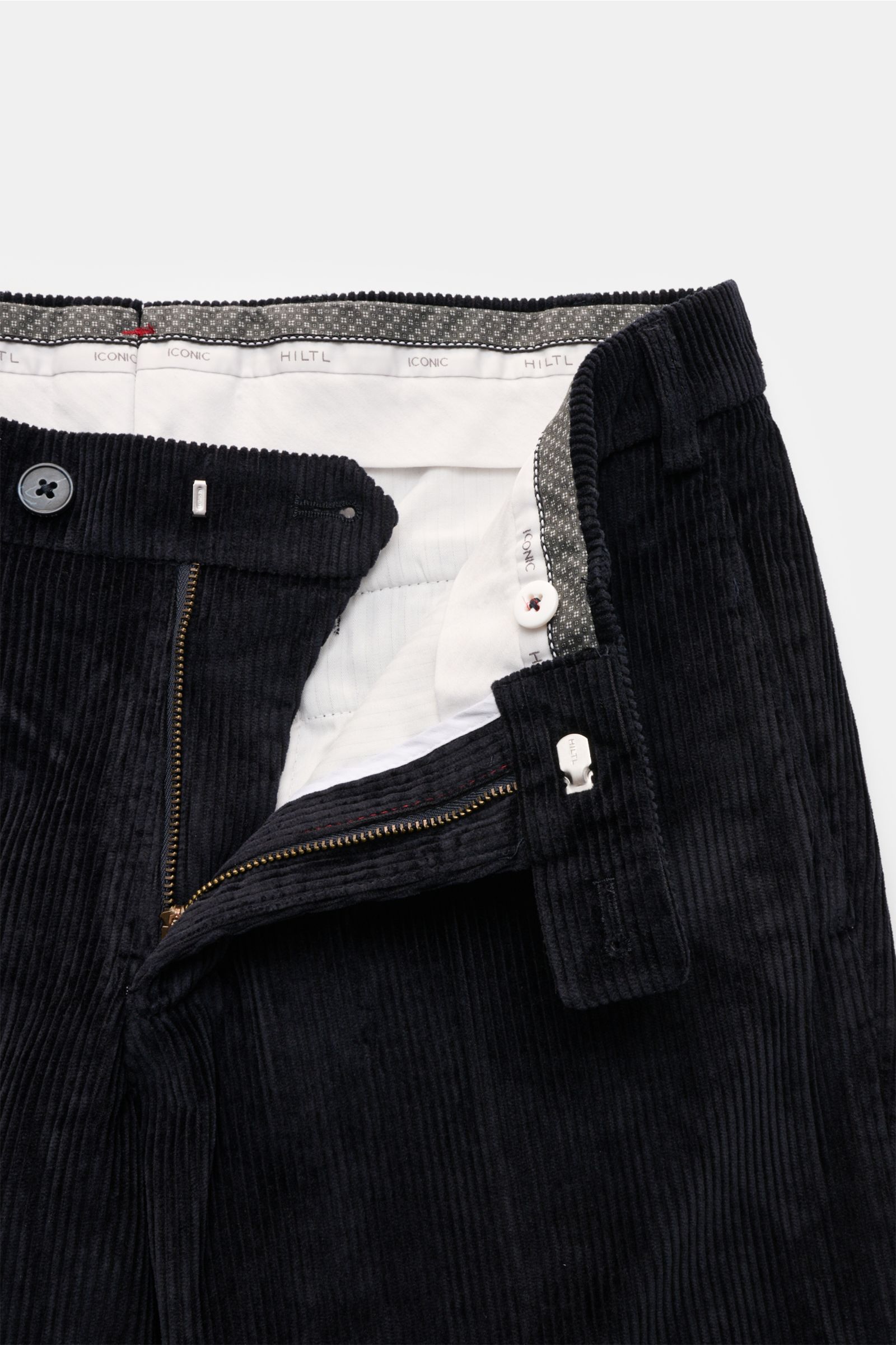 Nahaufnahme der geöffneten Hiltl Cordhose 'Parma' navy aus samtigem Baumwollcord mit Reißverschluss, Bundknopf und Innenbund-Detail.