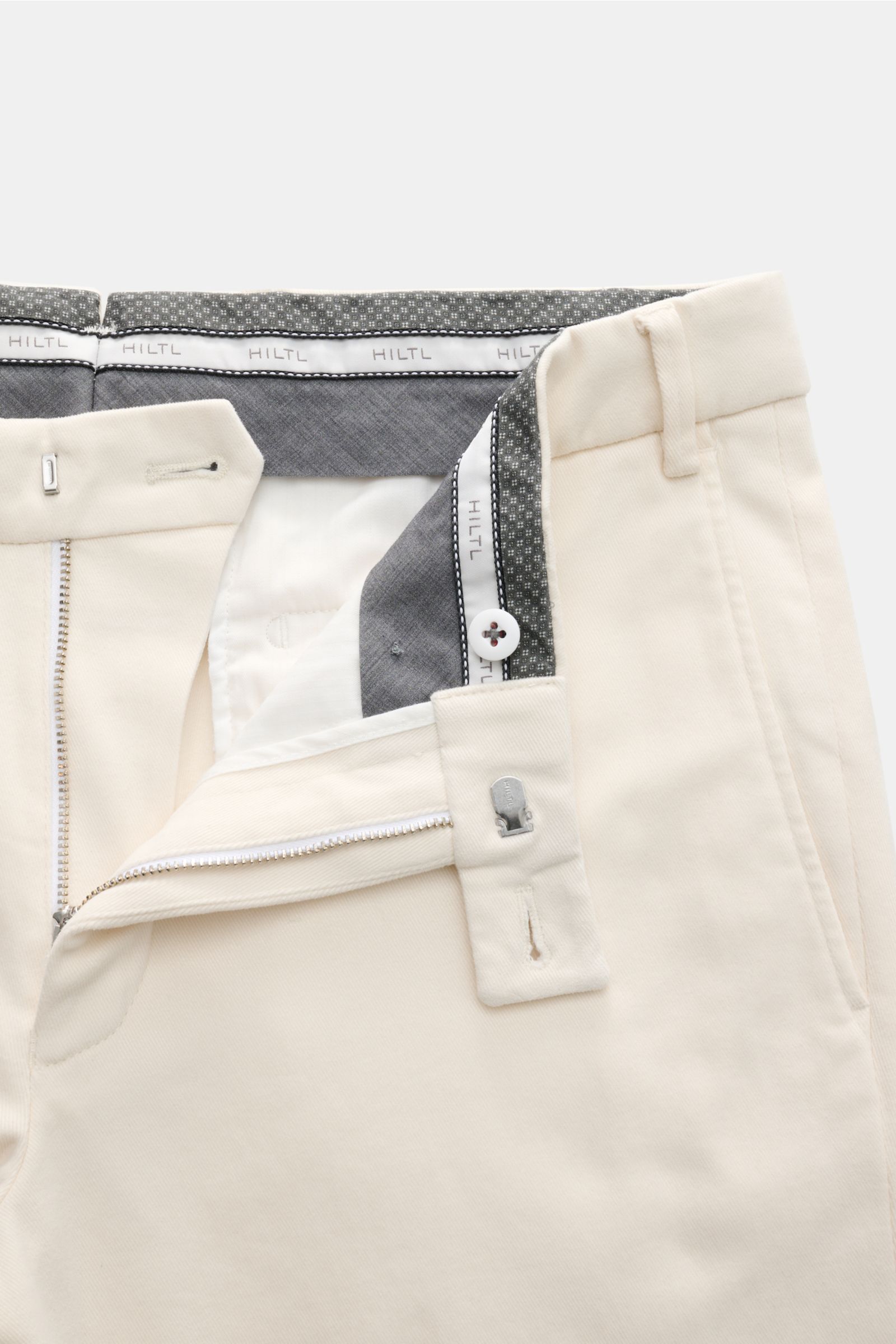 Hiltl Baumwollhose 'Parma' creme, Slim Fit Chino-Hose aus elastischer Baumwolle, Vorderansicht mit offenem Reißverschluss und Bundknopf.