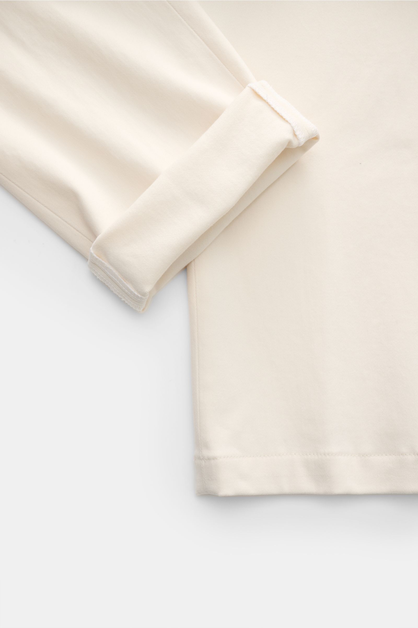 Nahaufnahme der umgeschlagenen Beinöffnung und unteren Partien der Hiltl Baumwollhose 'Parma' creme aus elastischer Baumwolle im Slim Fit.