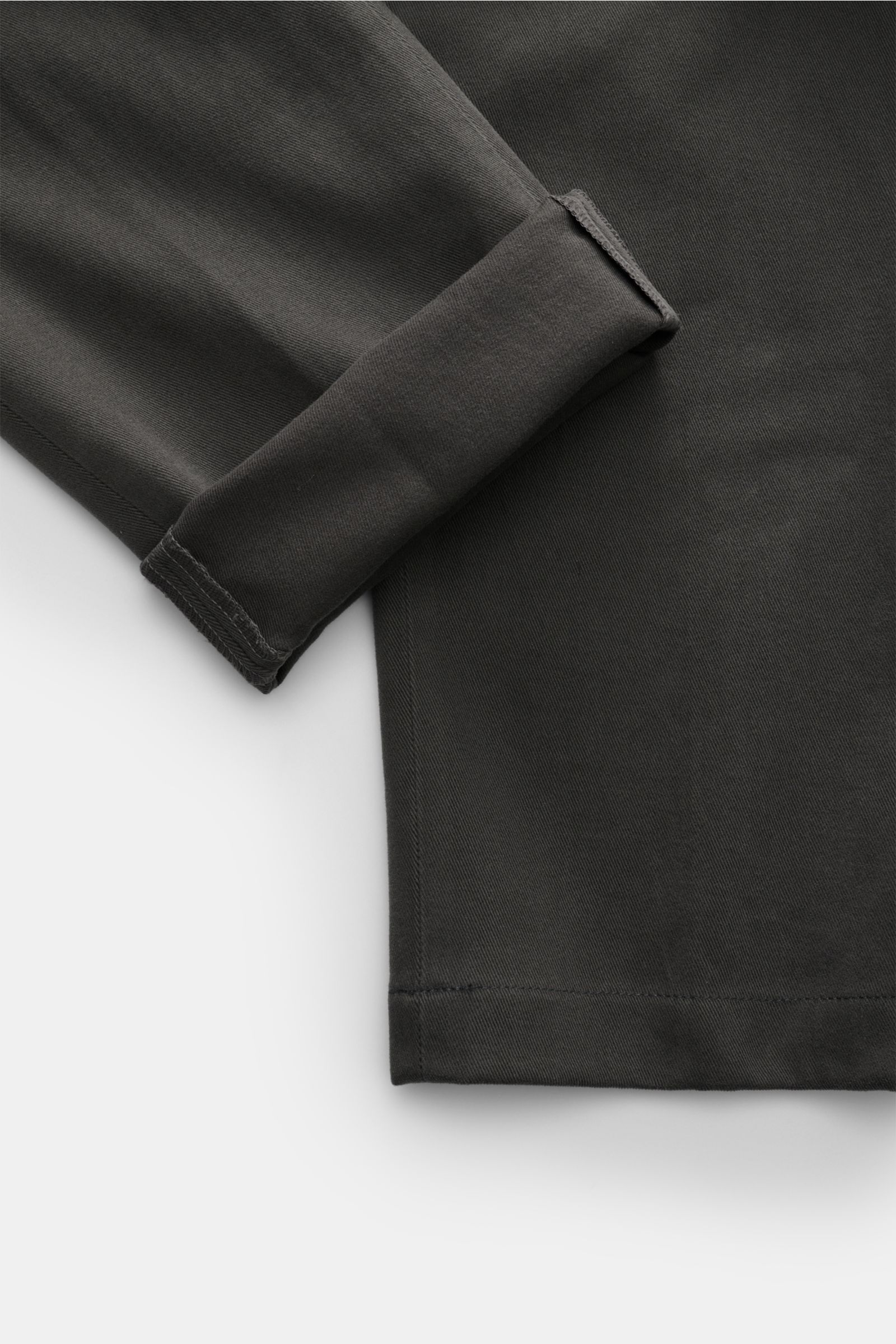 Nahaufnahme der dunkelgrauen Hiltl Baumwollhose 'Parma', Slim Fit, schmal zulaufend, aus elastischer Baumwolle mit umgeschlagenem Saum, Detailfoto von unten.