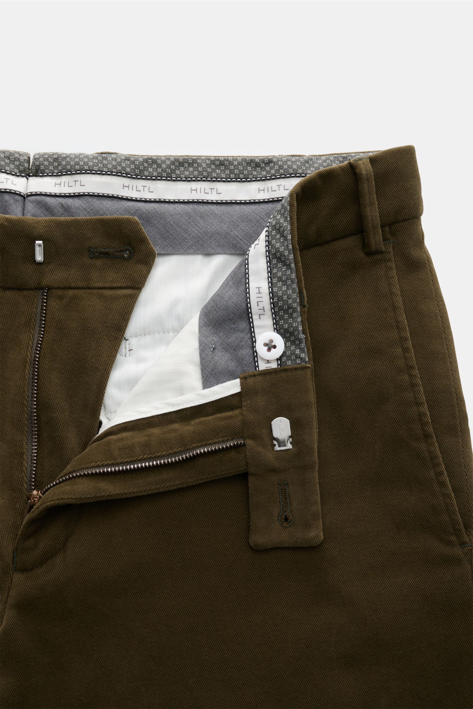 Nahaufnahme der geöffneten Hiltl Baumwollhose 'Parma' dark olive im Chino-Stil, Slim Fit, elastische Baumwolle, Reißverschluss mit Bundknopf, weicher Griff.