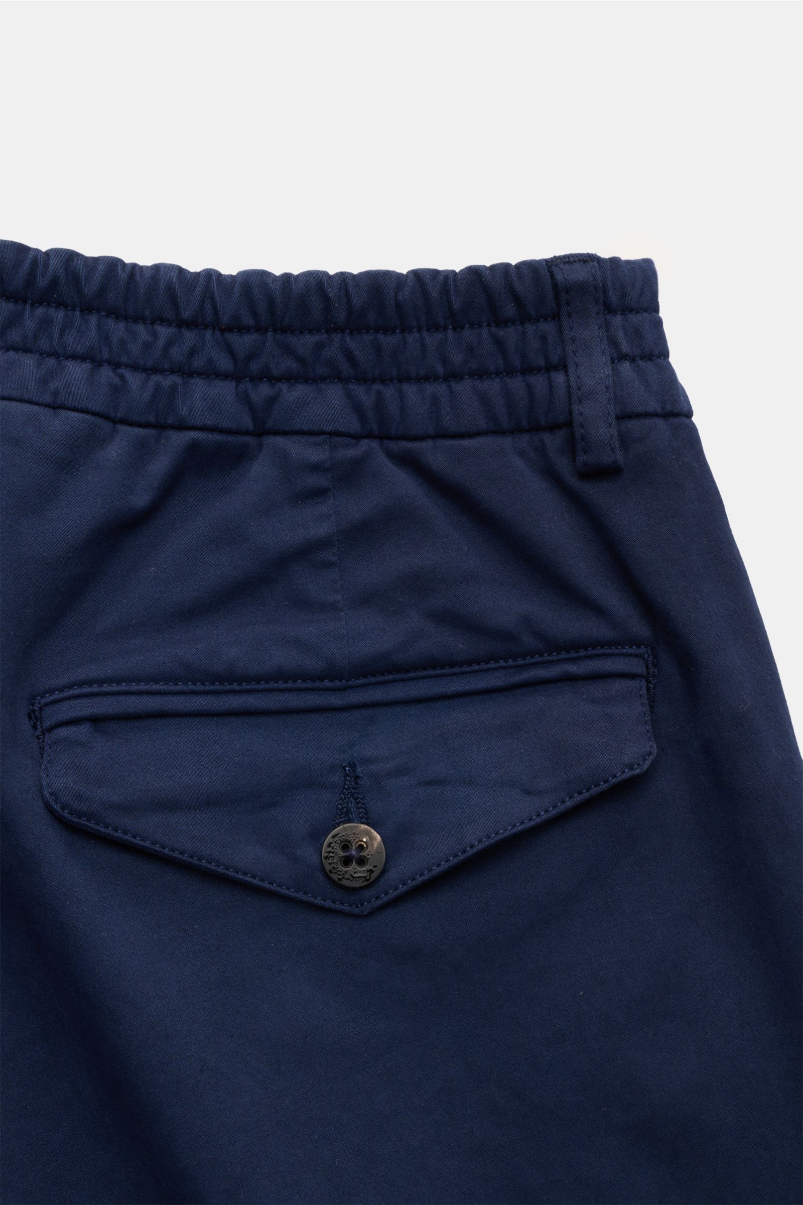 Close-up rear view of 04651/ A trip in a bag Cotton trousers 'Flex' navy showcasing a partially elasticated waistband and button-flap back pocket.

Description:  
Modern fit for everyday looks: The comfortable cotton trousers 'Flex' by 04651/ A TRIP IN