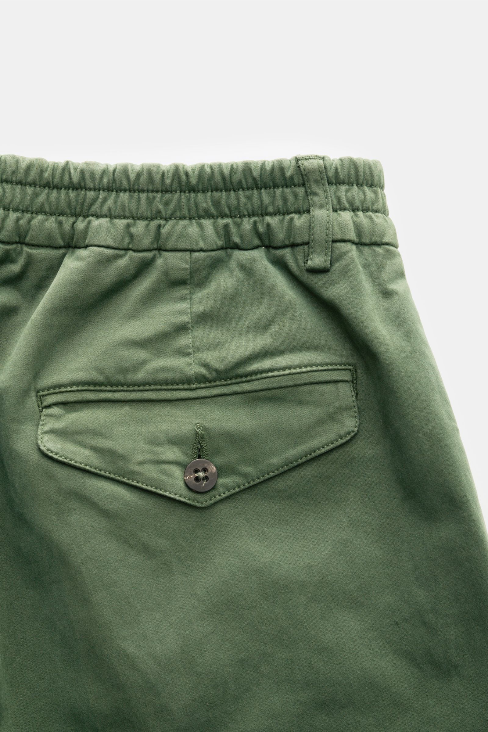 04651/ A trip in a bag Baumwollhose 'Flex' grün, Detailansicht der Rückseite mit geknöpfter Gesäßtasche, teils elastischem Bund und weichem Popeline-Stoff.