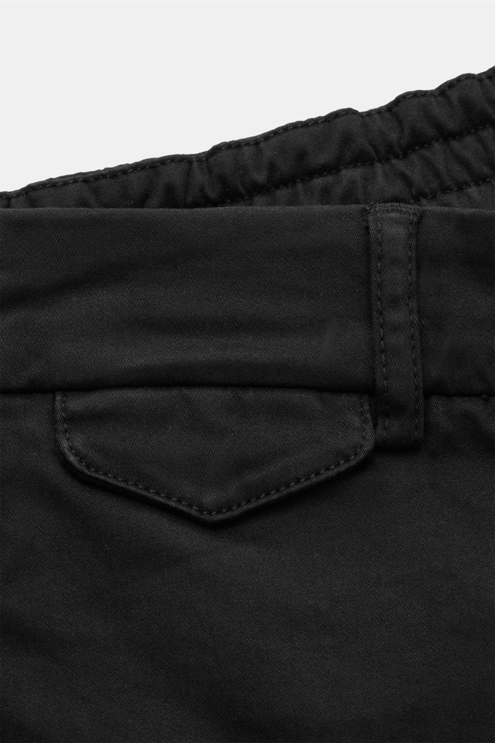 Nahaufnahme der schwarzen 04651/ A trip in a bag Baumwollhose 'Flex' mit teileslastischem Bund, geknöpfter Gesäßtasche und Popeline-Stoff.