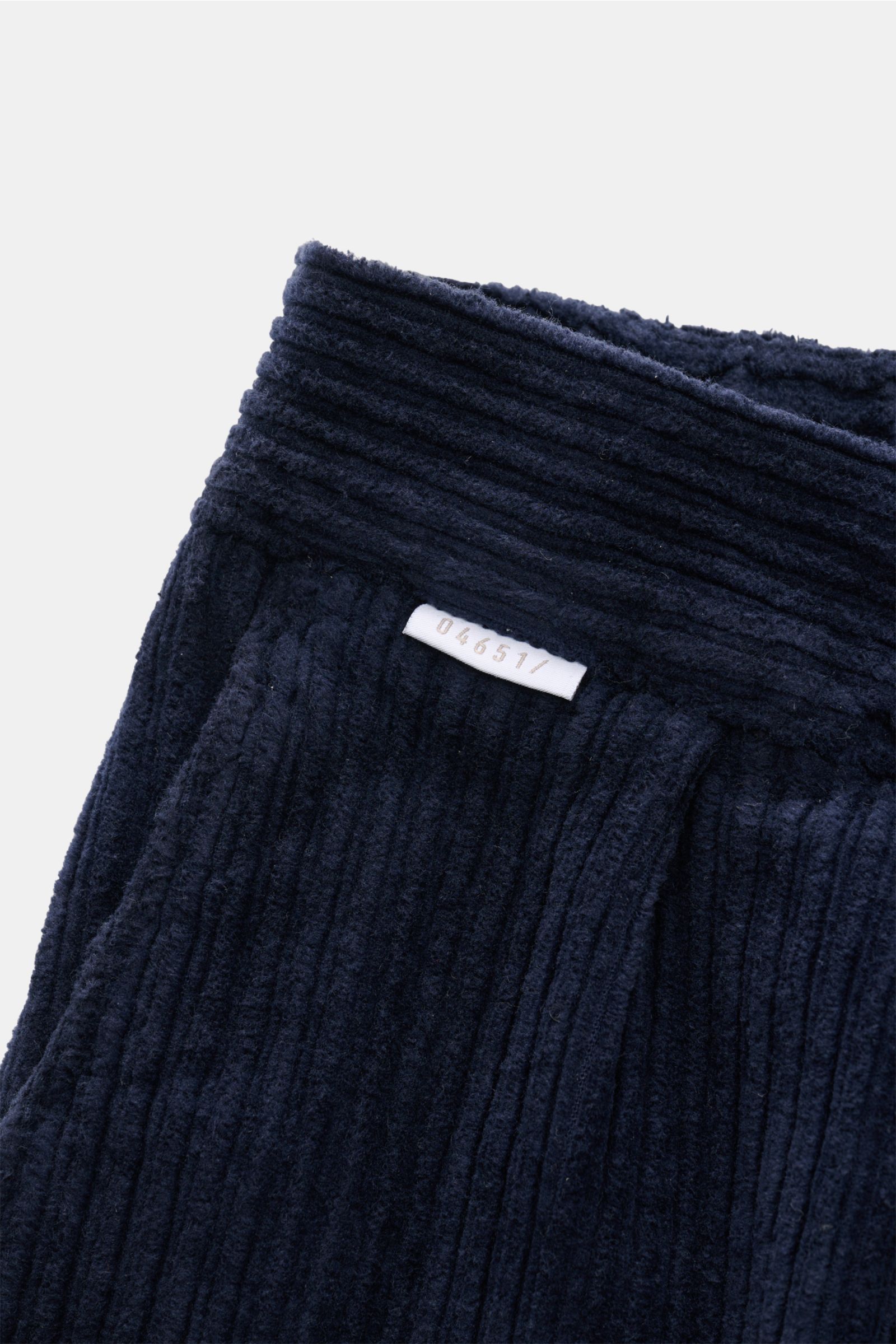 Nahaufnahme der Taille der 04651/ A trip in a bag Cordhose navy aus Baumwoll-Cord mit doppelter Bundfalte, französischer Tasche und kleinem Weblabel.