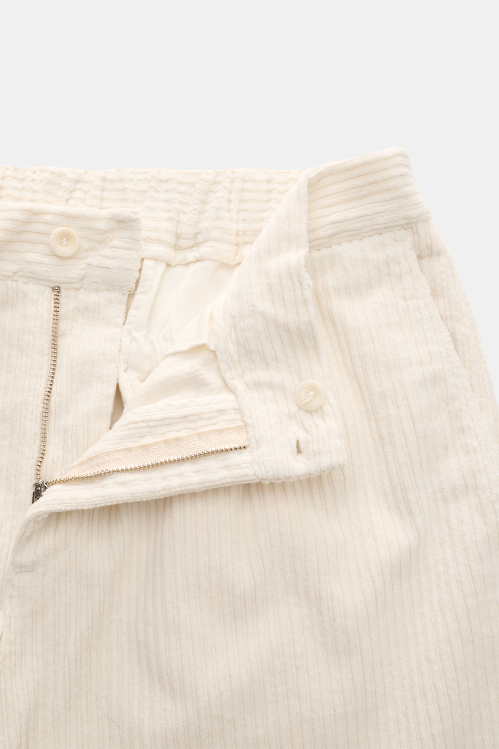04651/ A trip in a bag Cordhose creme, Nahaufnahme der geöffneten Bundfalte mit Reißverschluss, Knopf und feinem Baumwoll-Cord.