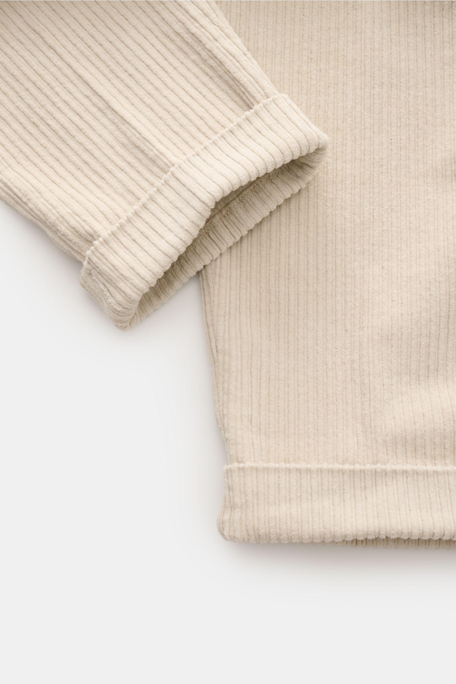 Helles Detailbild der 04651/ A trip in a bag Cordhose sand aus Baumwoll-Cord, zeigt fixierten Saumaufschlag und weichen Griff.