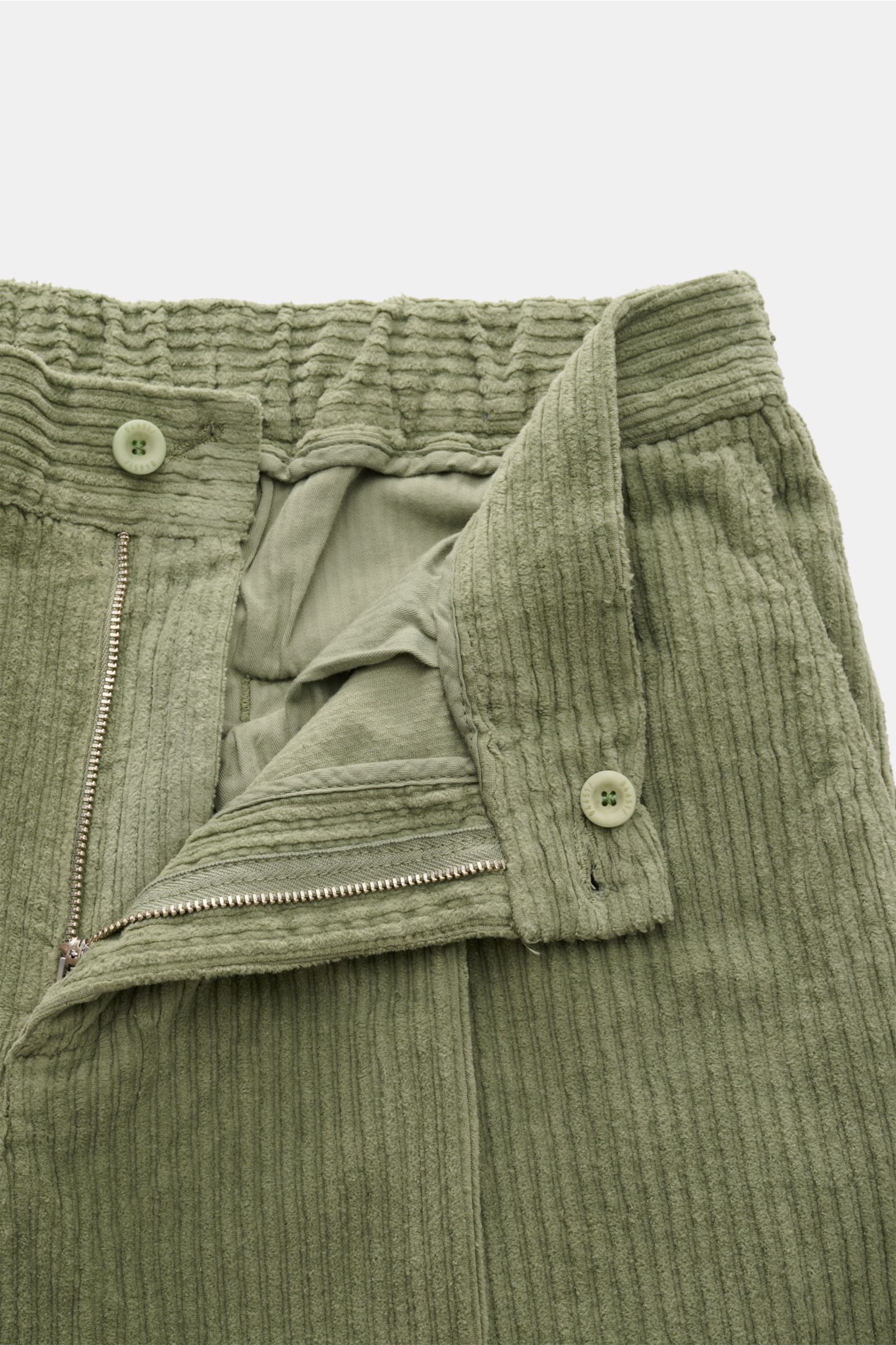 04651/ A trip in a bag Cordhose graugrün aus Baumwoll-Cord mit doppelter Bundfalte, Reißverschluss, Bundknopf, schmal zulaufend, frontal fotografiert.