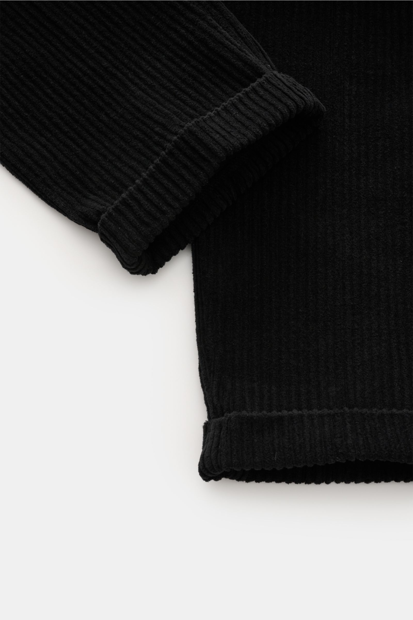 Schwarzer Cordstoff mit breiten Rippen, Detailaufnahme der fixierten Saumaufschläge der 04651/ A trip in a bag Cordhose schwarz aus Baumwoll-Cord.