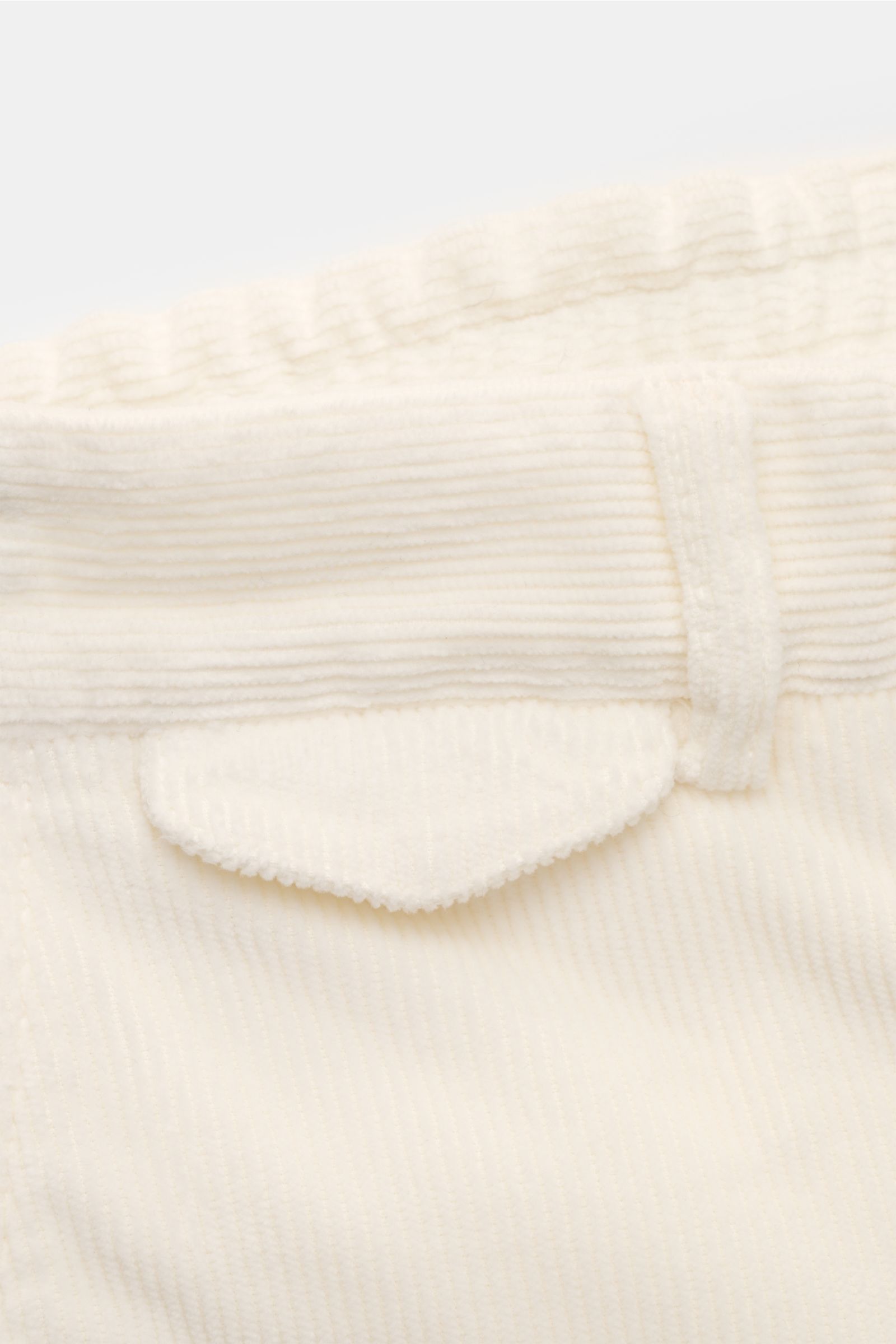 Close-up rear view of 04651/ A trip in a bag Corduroy trousers cream showing soft, garment-dyed corduroy fabric and button flap pocket. Welcome to the Autumn Winter Collection by 04651/ A TRIP IN A BAG – inspired by Finland’s contrasts between city and