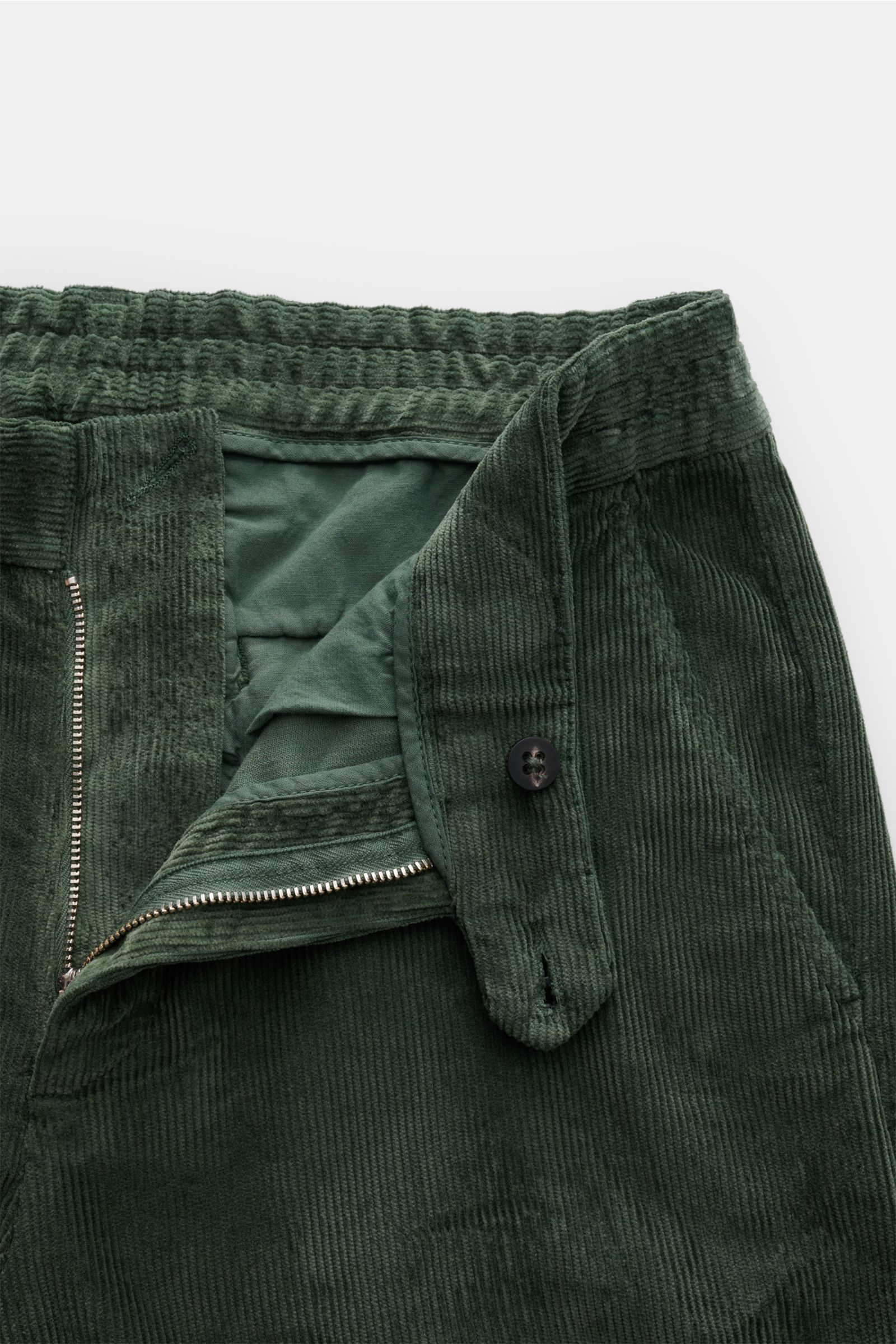 Grüne 04651/ A trip in a bag Cordhose aus Baumwoll-Modal-Cord, slim Fit, teils elastischer Bund, Reißverschluss, Knopf, französische Taschen, Detailansicht.