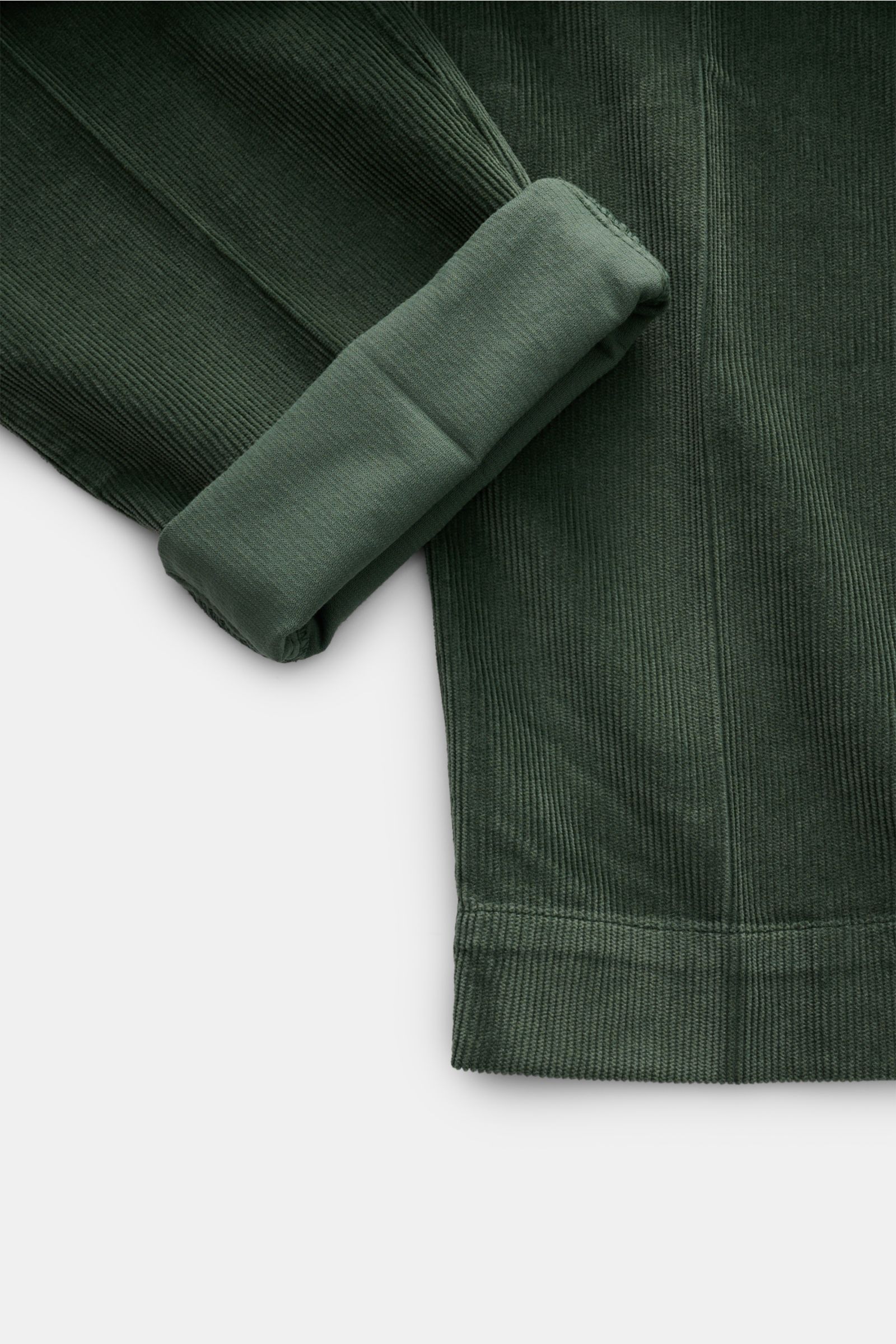 04651/ A trip in a bag Cordhose grün, close-up von Bein mit umgeschlagenem Saum, garment dyed Cord aus Baumwolle und Modal, Slim Fit, knöchellang, mit Stretch.