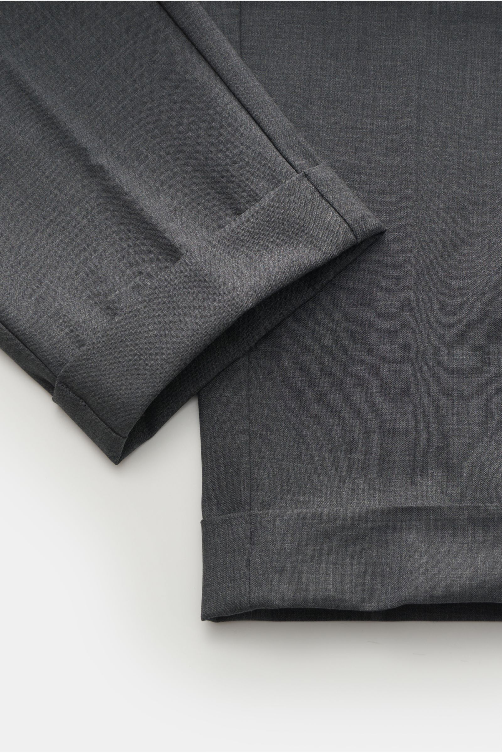 The Product is the Hero Woll-Jogpants dunkelgrau, Detailaufnahme von knöchellangem, schmal zulaufendem Bein mit fixiertem Saumaufschlag aus leicht elastischer Schurwolle.