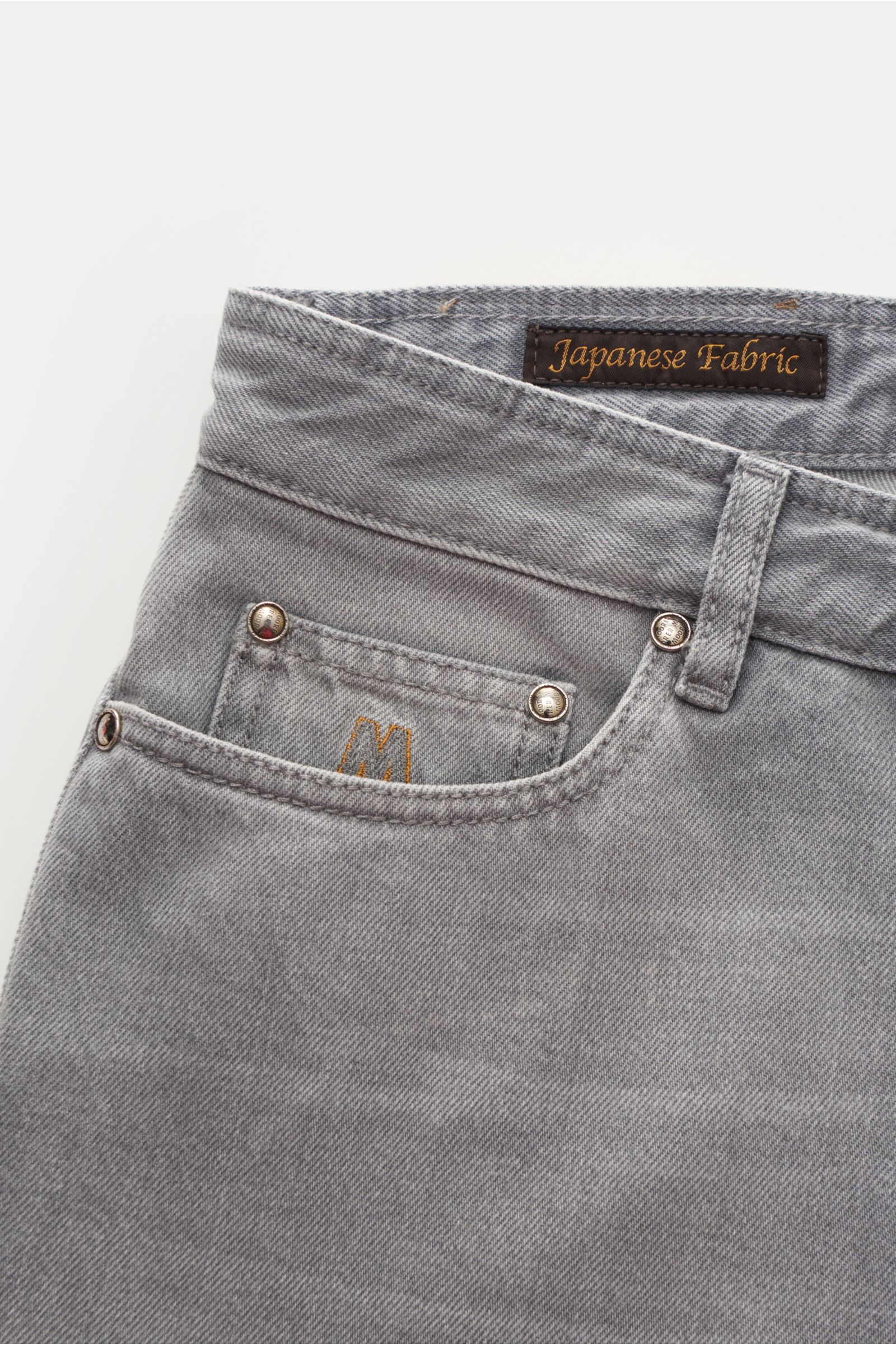 Moorer Jeans 'Pavel' hellgrau, Nahaufnahme seitlich oben, Denim aus reiner Baumwolle, slim fit, Used-Waschung, Button Fly, Five-Pocket-Stil, Münztasche mit Sticklogo, Gesäßtaschen mit Stitching, schmal geschnittene Wade, kontrastfarbenes Leather-Patch.