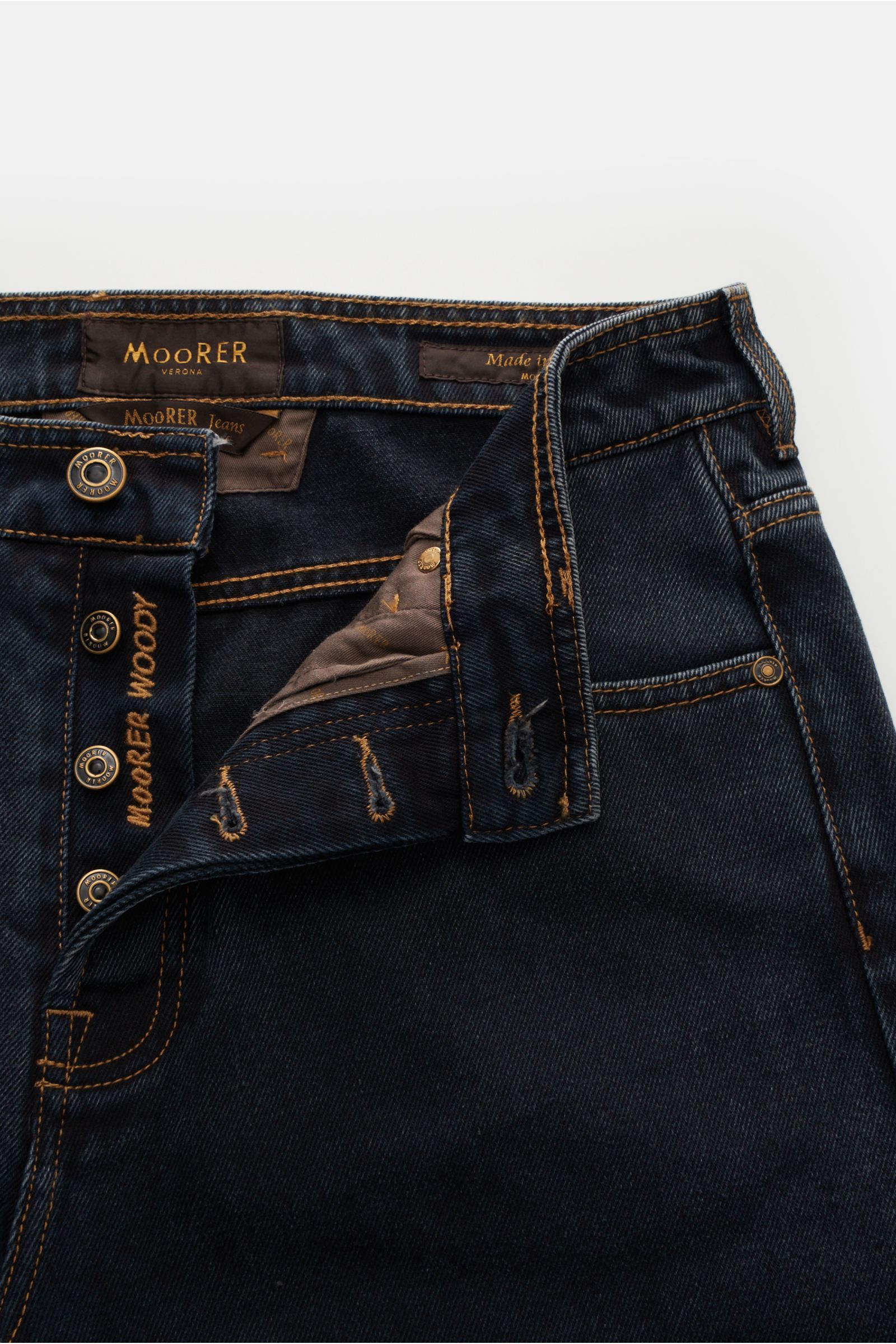 Moorer Jeans 'Woody' dunkelgrau aus reiner Baumwolle, Five-Pocket-Stil, Button Fly, kurzer Schnitt, Tapered Fit, Used-Waschung, Leather-Patch, Detailfoto von oben.