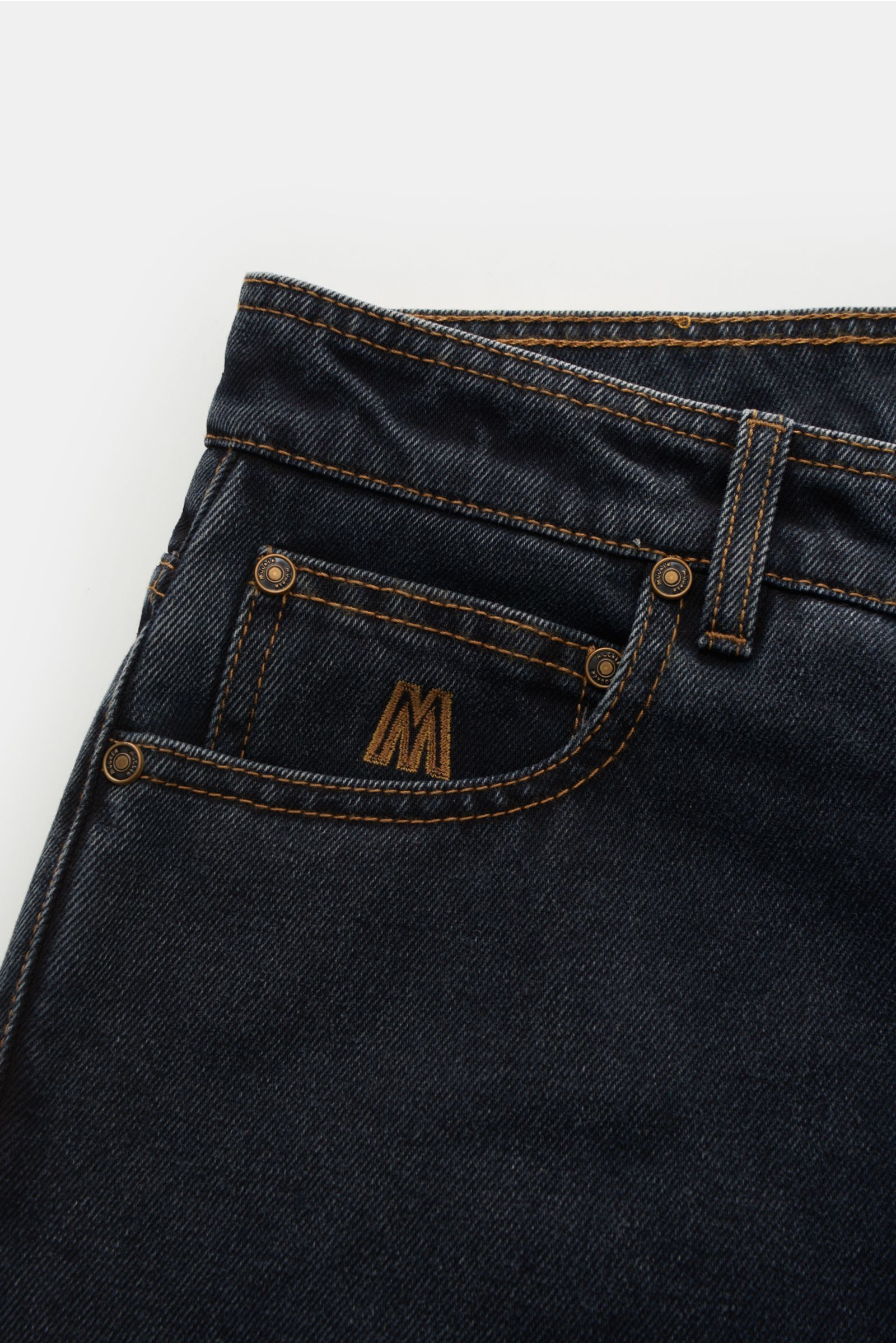 Moorer Jeans 'Woody' dunkelgrau aus Denim Baumwolle mit leicht griffiger Haptik, Used-Waschung, Button Fly, Five-Pocket, Sticklogo-Münztasche, Stitching-Gesäßtaschen und kontrastfarbenem Leather-Patch, Nahaufnahme von oben.