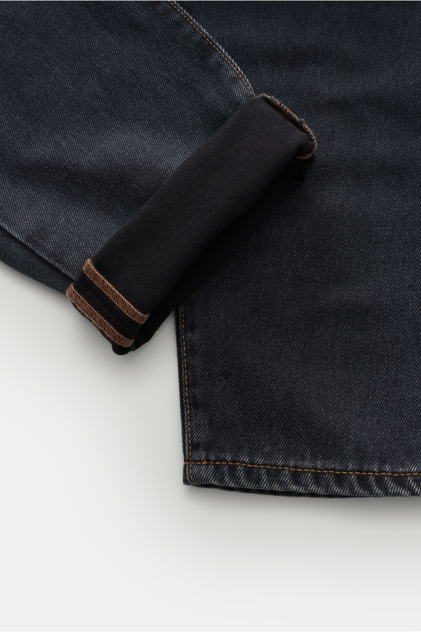 Moorer Jeans 'Woody' dunkelgrau, Detailaufnahme vom Bein mit Umschlag, Denim aus reiner Baumwolle, leicht griffig, Used-Waschung, Tapered Fit, kurzer Schnitt.