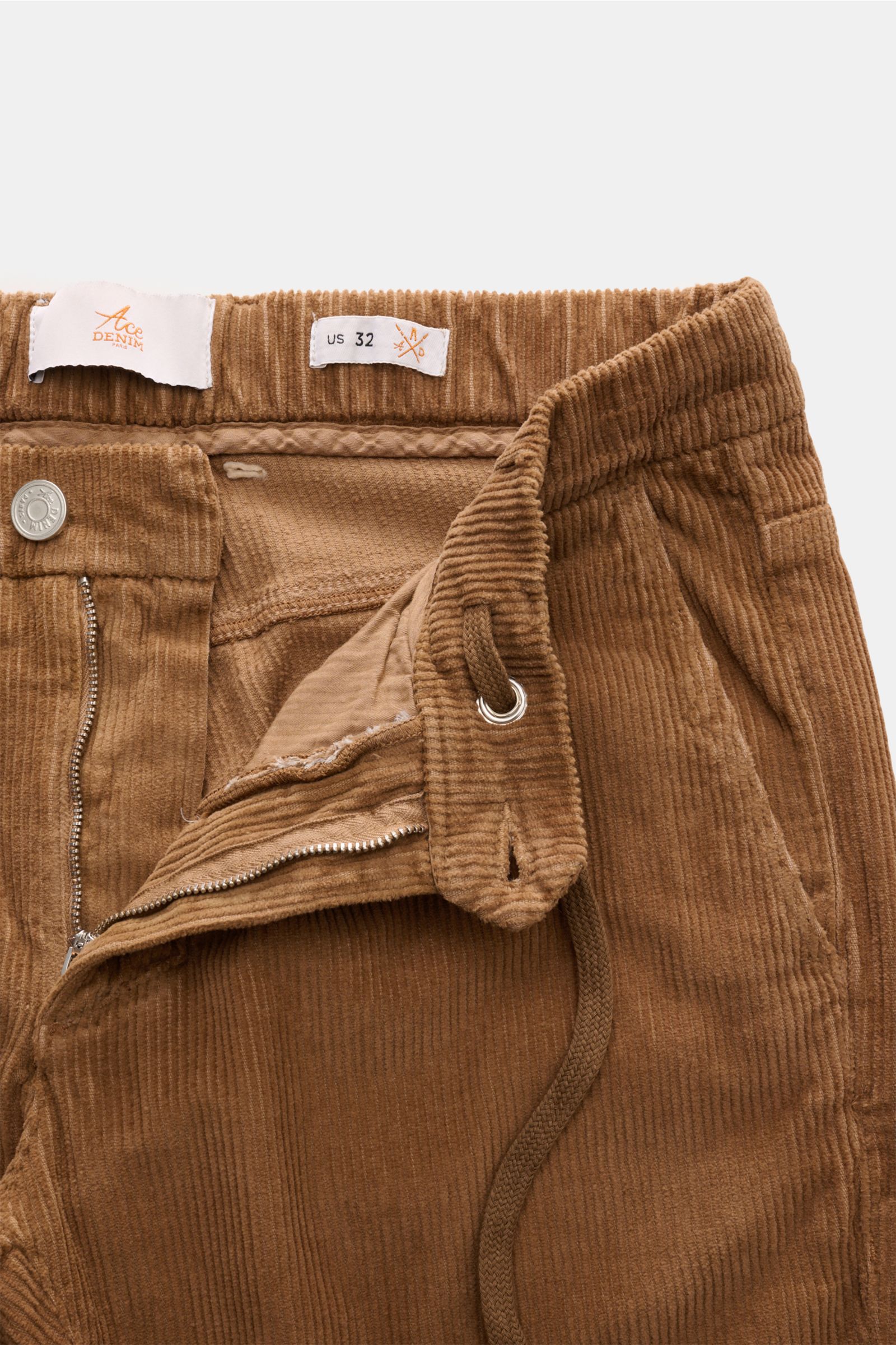 Ace Denim Cord-Jogpants camel aus reiner Baumwolle, Slim Fit, schmal zulaufend, mit Reißverschluss, Bundknopf, Tunnelzug und französischen Taschen, Nahaufnahme von oben.