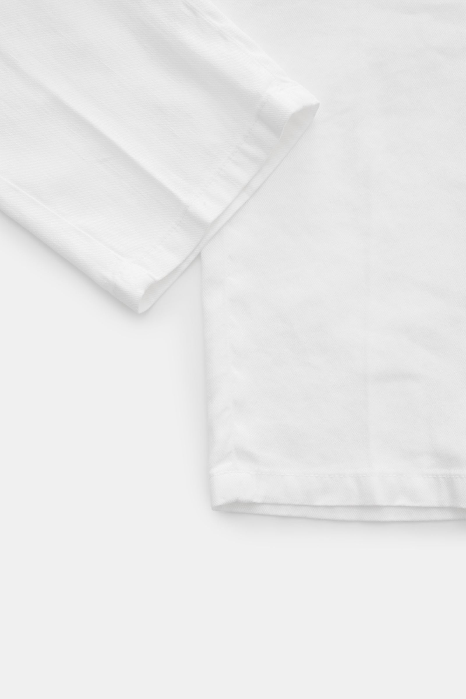 Marco Pescarolo Jogpants 'Caracciolo' weiß aus Leinen-Lyocell-Mix, Regular Fit, schmal zulaufend, mit Reißverschluss, Bundknopf und elastischem Bund, seitliche und paspelierte Gesäßtaschen, fixierter Saumaufschlag, Detailaufnahme von unten schräg.