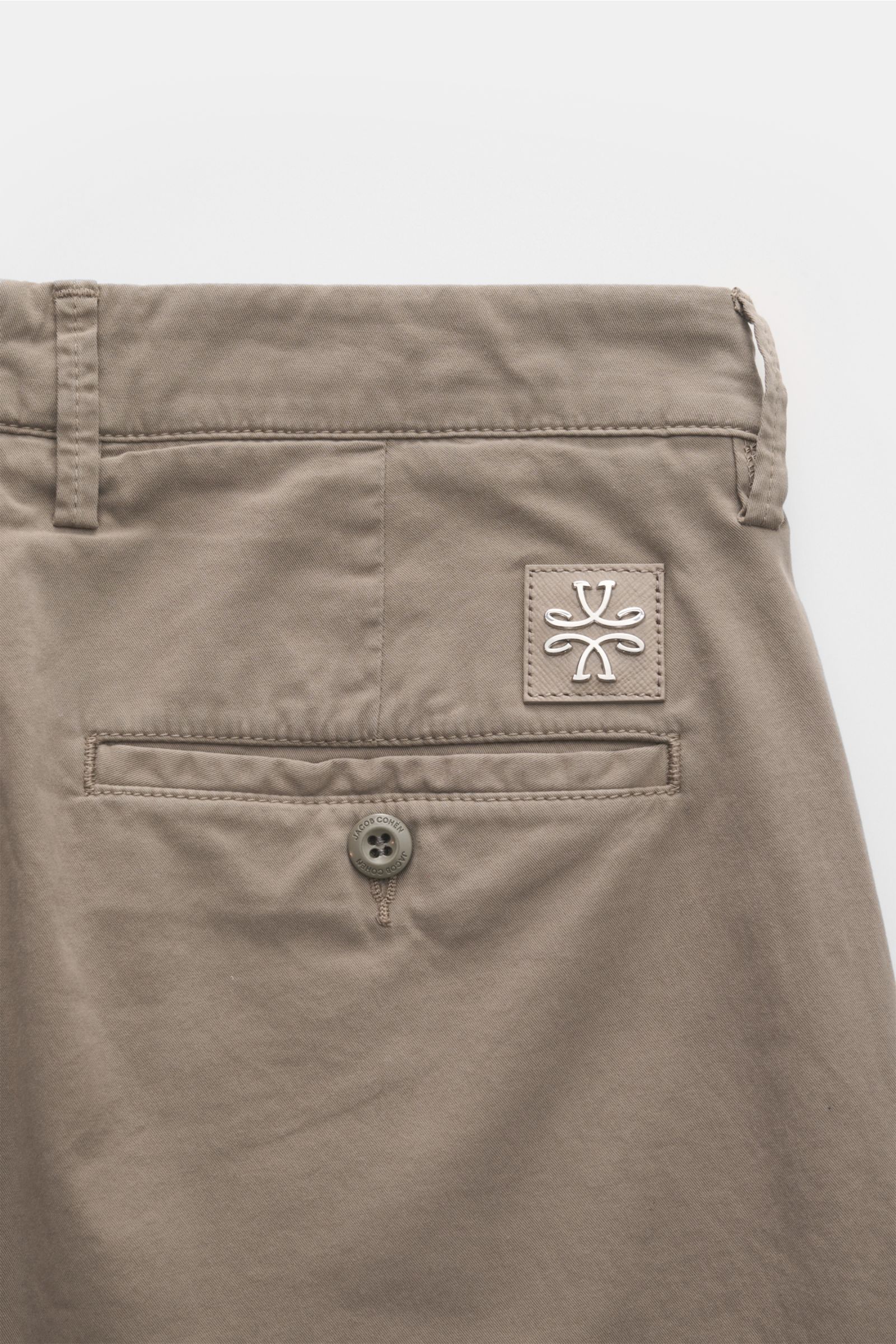 Close-up rear view of Jacob Cohen Chino 'Bobby' taupe slim fit pants in fine cotton twill with buttoned back pocket and leather logo patch.

Präzise, italienische Handwerkskunst - dafür steht das Label JACOB COHEN und kreiert mit der Chino 'Bobby' aus 