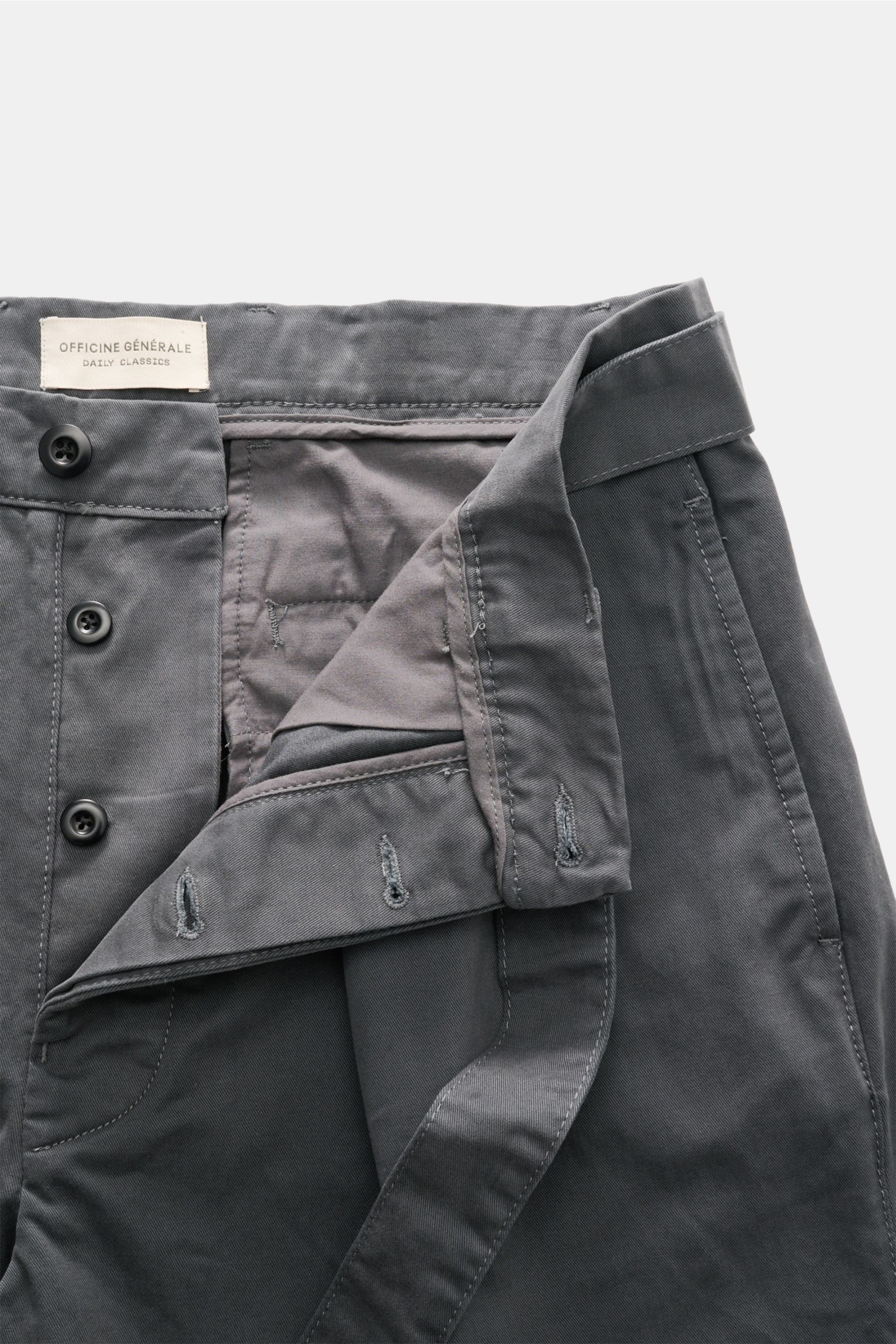 Close-up front view of Officine Générale Chinos dark grey showing button fly, belt loops, and waistband details in soft cotton twill.

Description: 
Parisian nonchalance at its most stylish: 